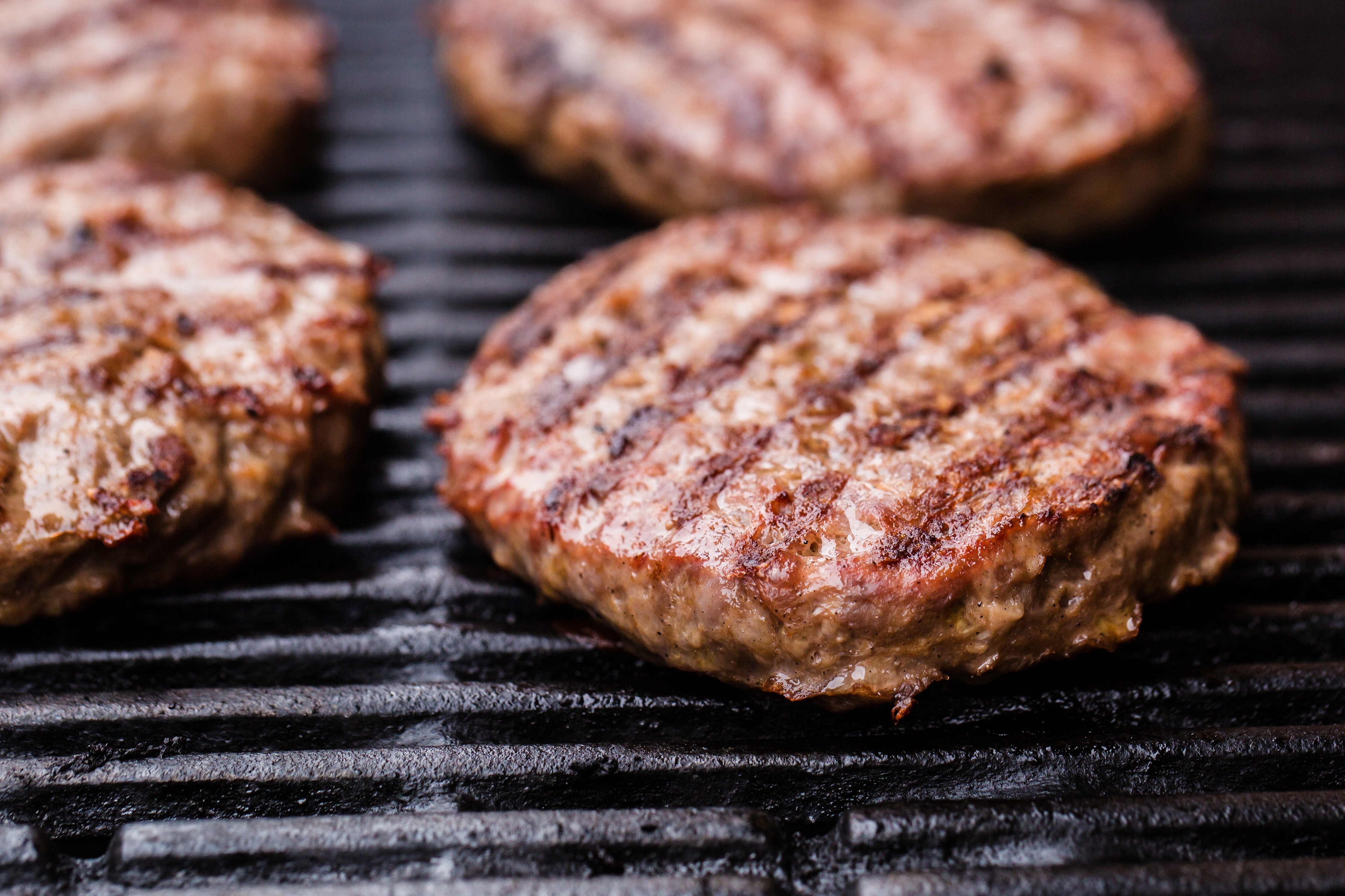 Patties cook on a grill. Shutterstock image via user x4wiz
