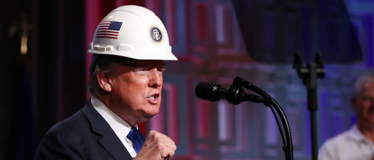 U.S. President Donald Trump dons a hard hat presented by the National Electrical Contractors Association (NECA) before addressing their convention in Philadelphia, Pennsylvania, U.S., October 2, 2018. REUTERS/Jonathan Ernst