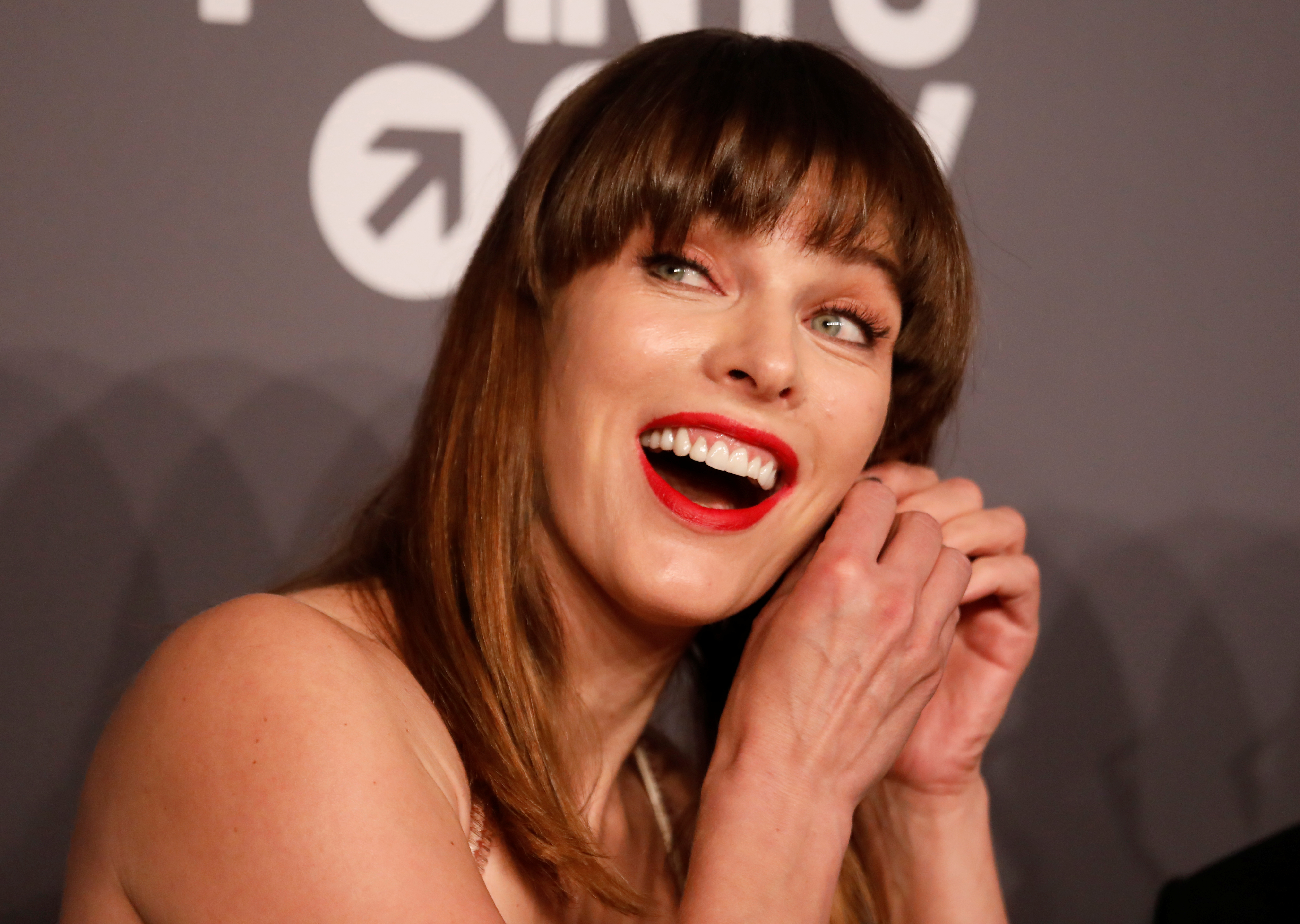 Milla Jovovich puts on her earring on the red carpet for the amfAR gala in New York, U.S., February 6, 2019. REUTERS/Shannon Stapleton 