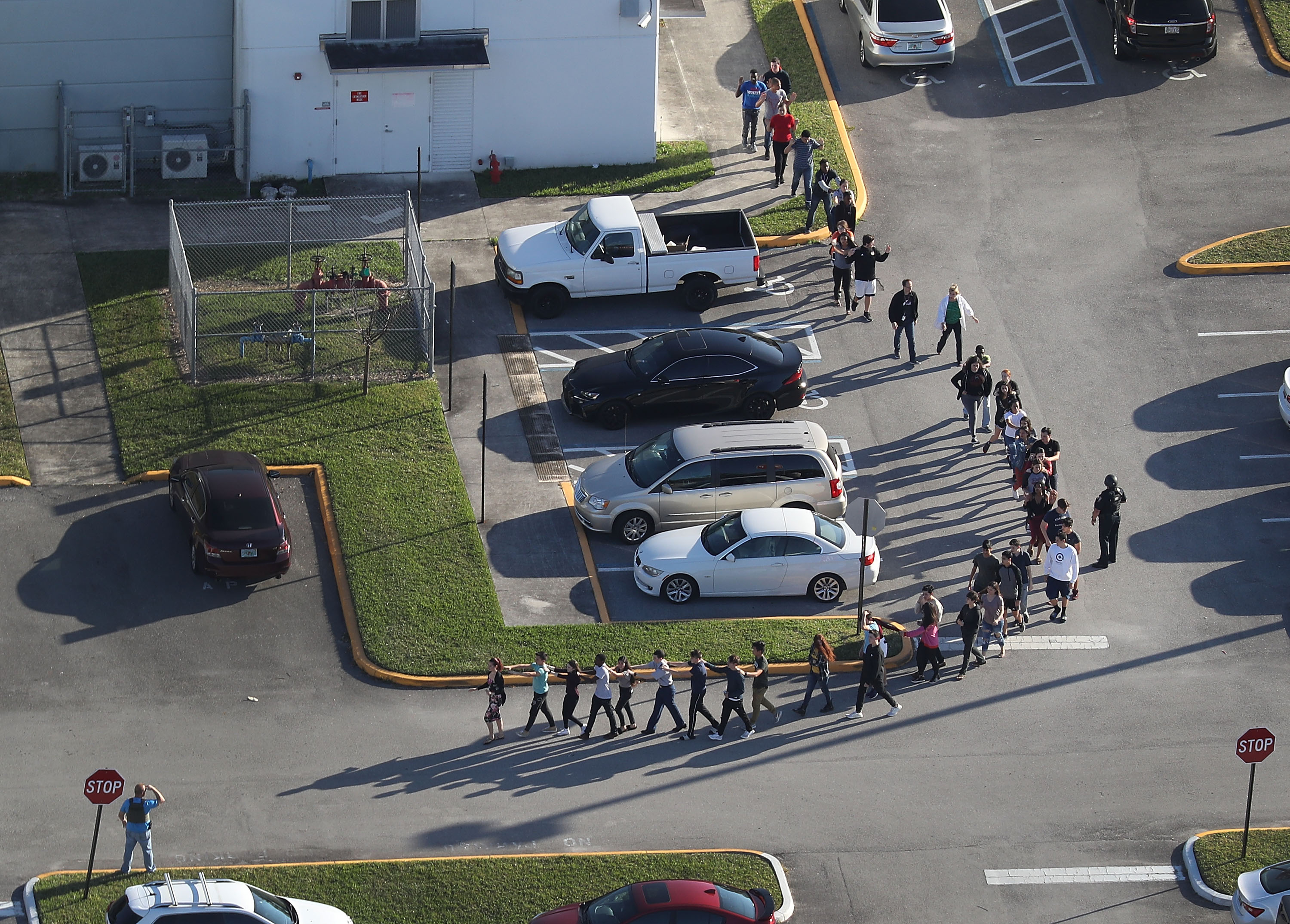 People are brought out of the Marjory Stoneman Douglas High School after a shooting at the school that reportedly killed and injured multiple people on February 14, 2018 in Parkland, Florida. (Photo by Joe Raedle/Getty Images)