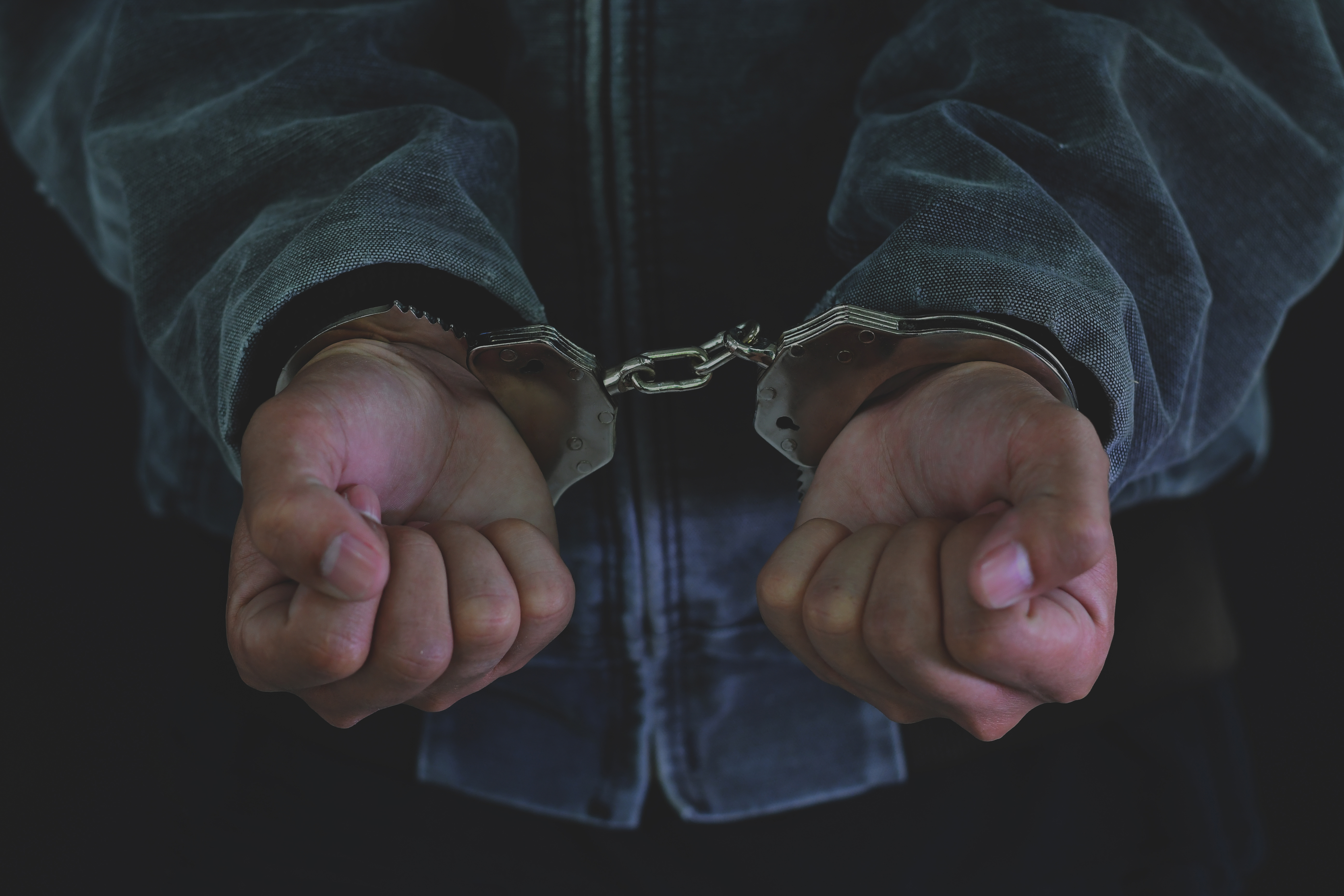 A suspect is in handcuffs. Shutterstock image via Lovely Bird