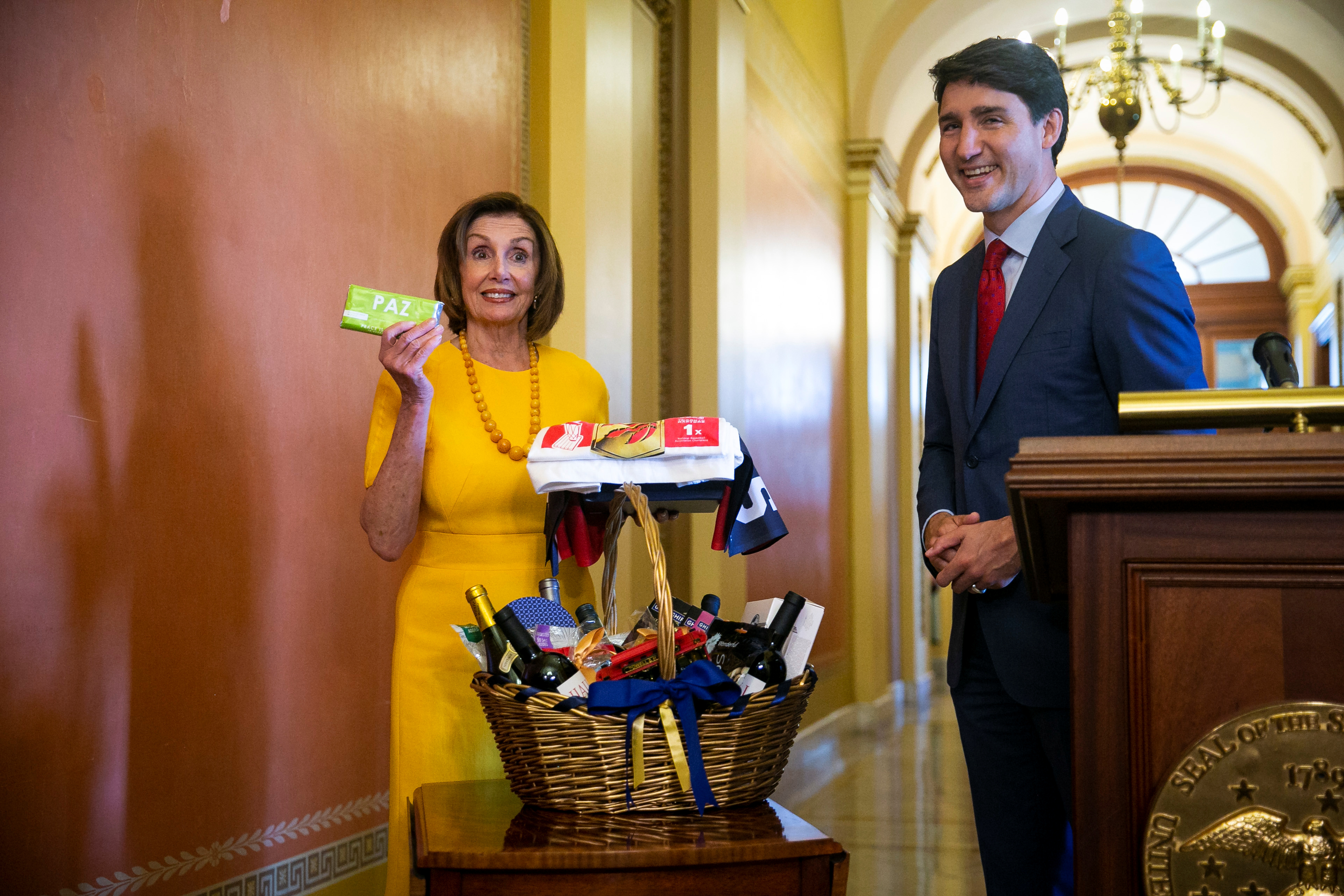 Canada's Prime Minister Justin Trudeau, hands a gift to U.S. House Speaker Nancy Pelosi (D-CA) as they settle a wager on the Toronto Raptors defeating the Golden State Warriors in the 2019 NBA Finals, on Capitol Hill in Washington, U.S. June 20, 2019. REUTERS/Al Drago 
