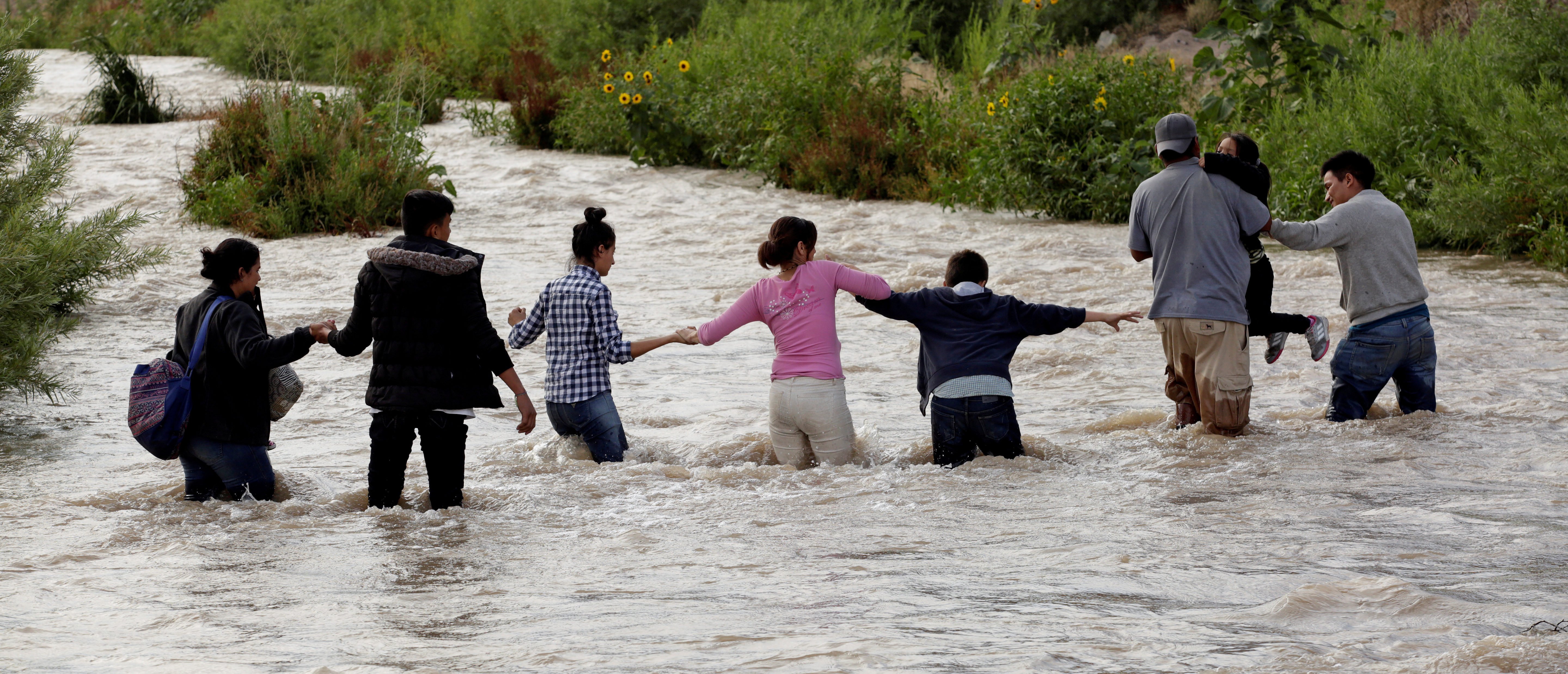 FILE PHOTO: Migrants from Central America form a human chain to cross the Rio Bravo river to enter illegally into the United States to turn themselves in to request for asylum in El Paso, Texas, U.S., as seen from Ciudad Juarez, Mexico June 11, 2019. Picture taken June 11, 2019. REUTERS/Jose Luis Gonzalez