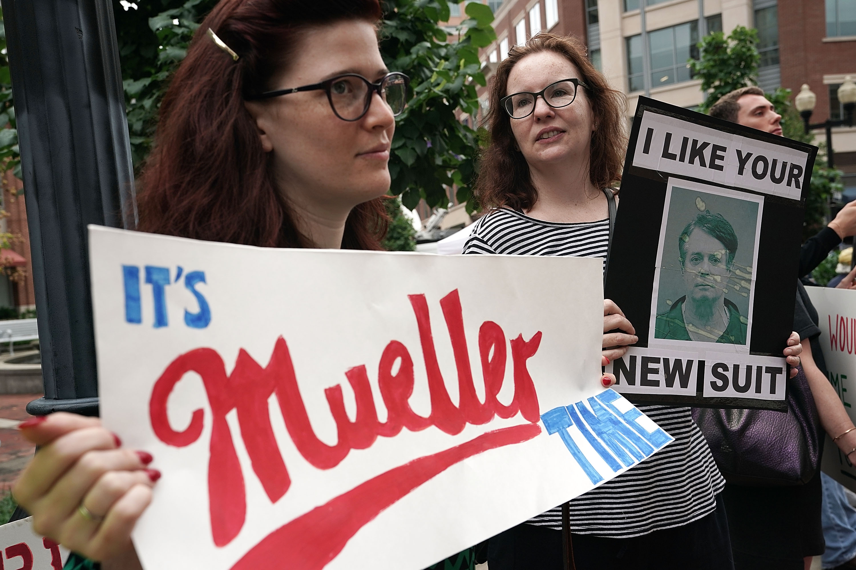 Activists hold signs during a protest outside the Albert V. Bryan United States Courthouse prior to the first day of the trial of former Trump campaign chairman Paul Manafort July 31, 2018 in Alexandria, Virginia. (Photo by Alex Wong/Getty Images)