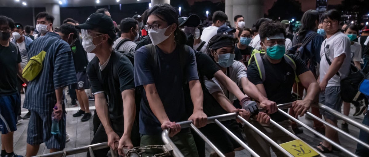 Protesters move a barricade during a clash at Legislative Council after a rally against the extradition law proposal at the Central Government Complex on June 10, 2019 in Hong Kong. (Photo by Anthony Kwan/Getty Images)