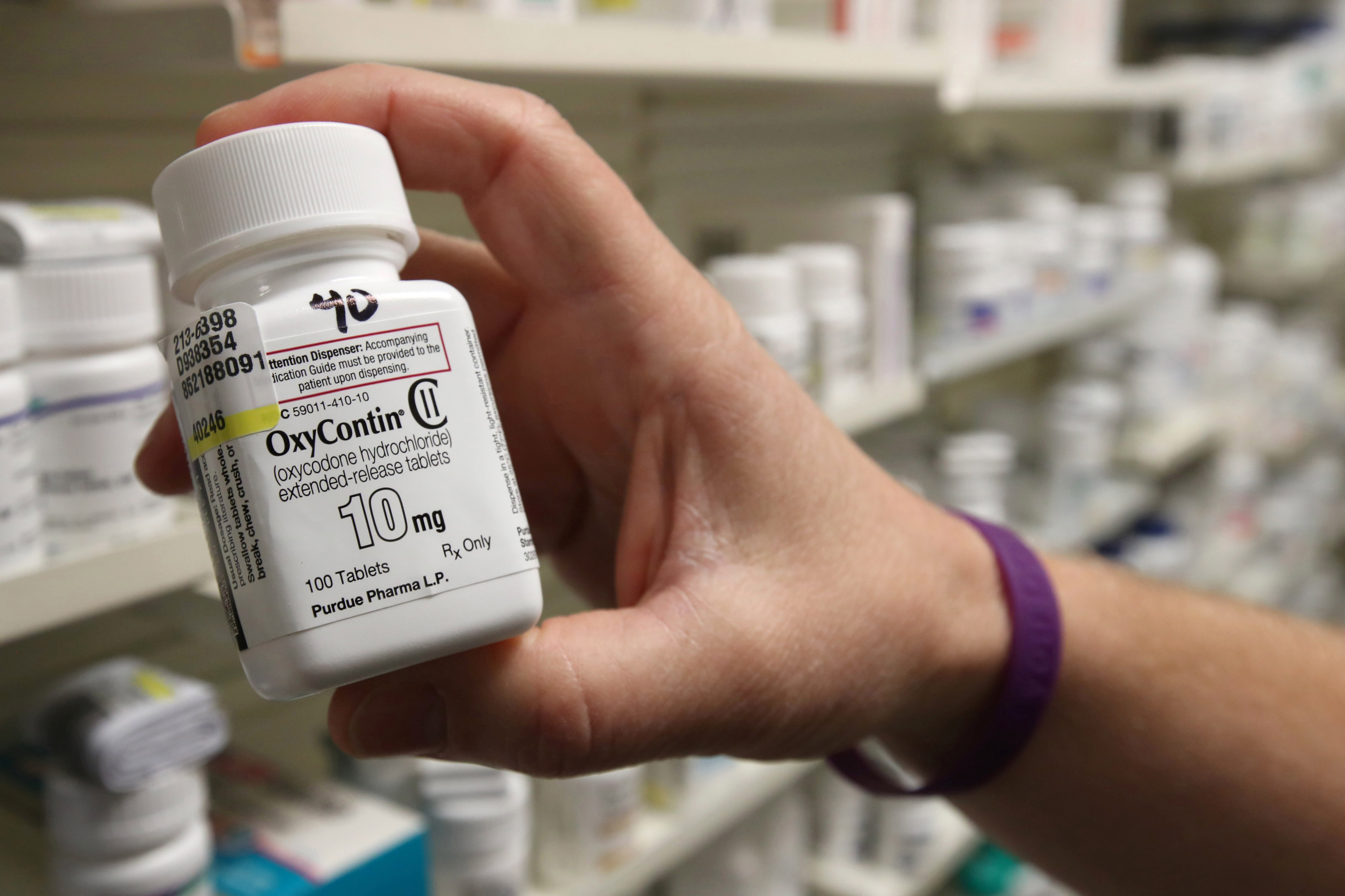 A pharmacist holds a bottle OxyContin made by Purdue Pharma at a pharmacy in Provo, Utah, U.S., May 9, 2019. REUTERS/George Frey
