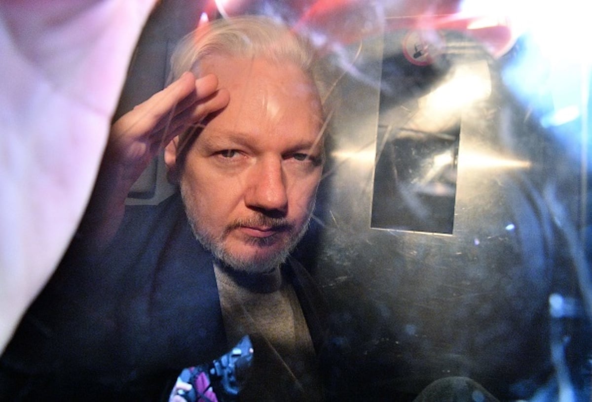 WikiLeaks founder Julian Assange gestures from the window of a prison van as he is driven out of Southwark Crown Court in London on May 1, 2019, after having been sentenced to 50 weeks in prison for breaching his bail conditions in 2012. - A British judge on Wednesday sentenced WikiLeaks founder Julian Assange to 50 weeks in prison for breaching his bail conditions in 2012. Assange took refuge in Ecuador's London embassy to avoid extradition to Sweden and was only arrested last month after Ecuador withdrew his asylum status. (Photo by Daniel LEAL-OLIVAS / AFP) (Photo credit should read DANIEL LEAL-OLIVAS/AFP/Getty Images)