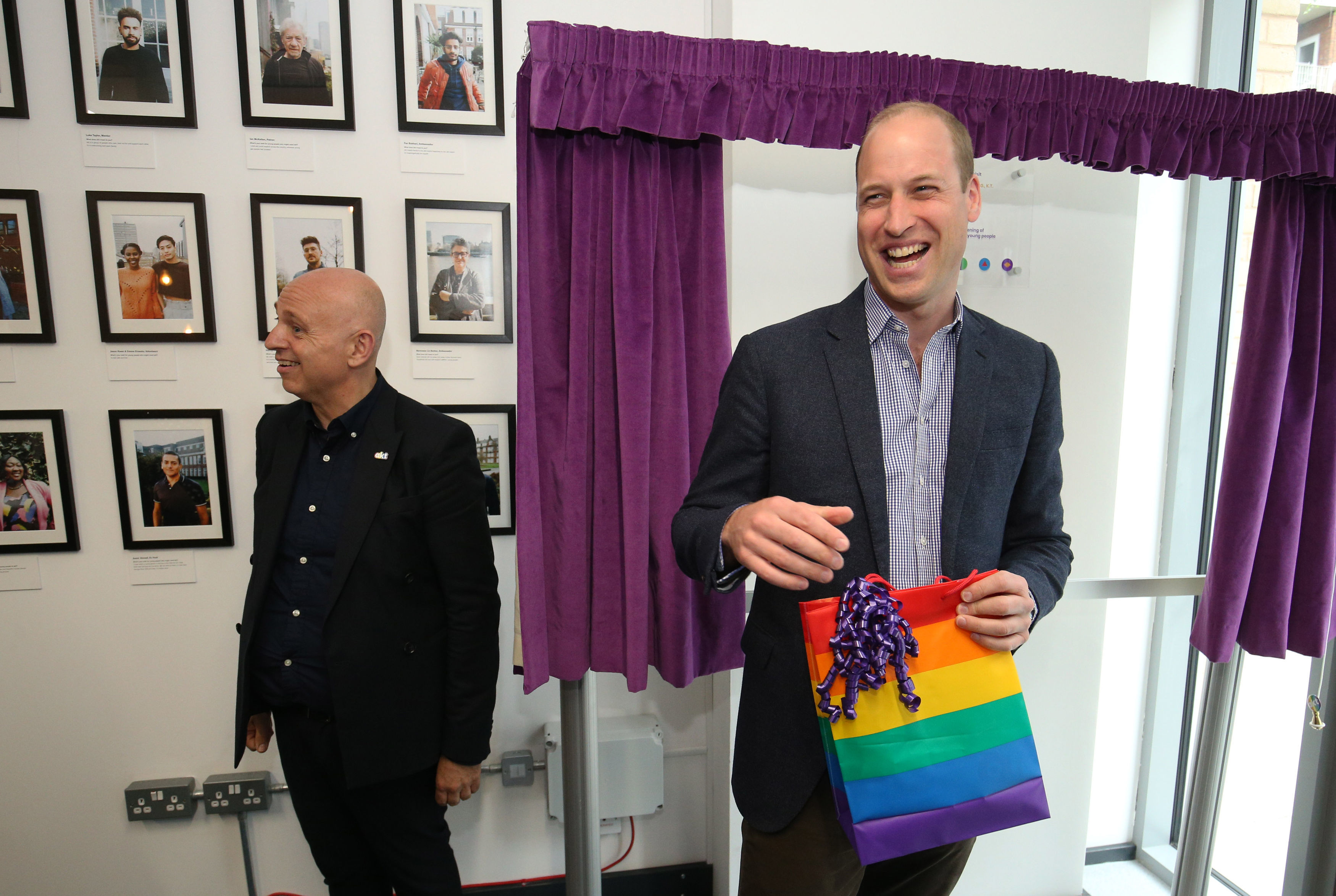 Britain's Prince William, Duke of Cambridge, reacts to receiving a gift bag from trust chief executive officer Tim Sigsworth during a visit to the Albert Kennedy Trust in London to learn about the issue of LGBTQ youth homelessness in London on June 26, 2019. (Photo credit JONATHAN BRADY/AFP/Getty Images)