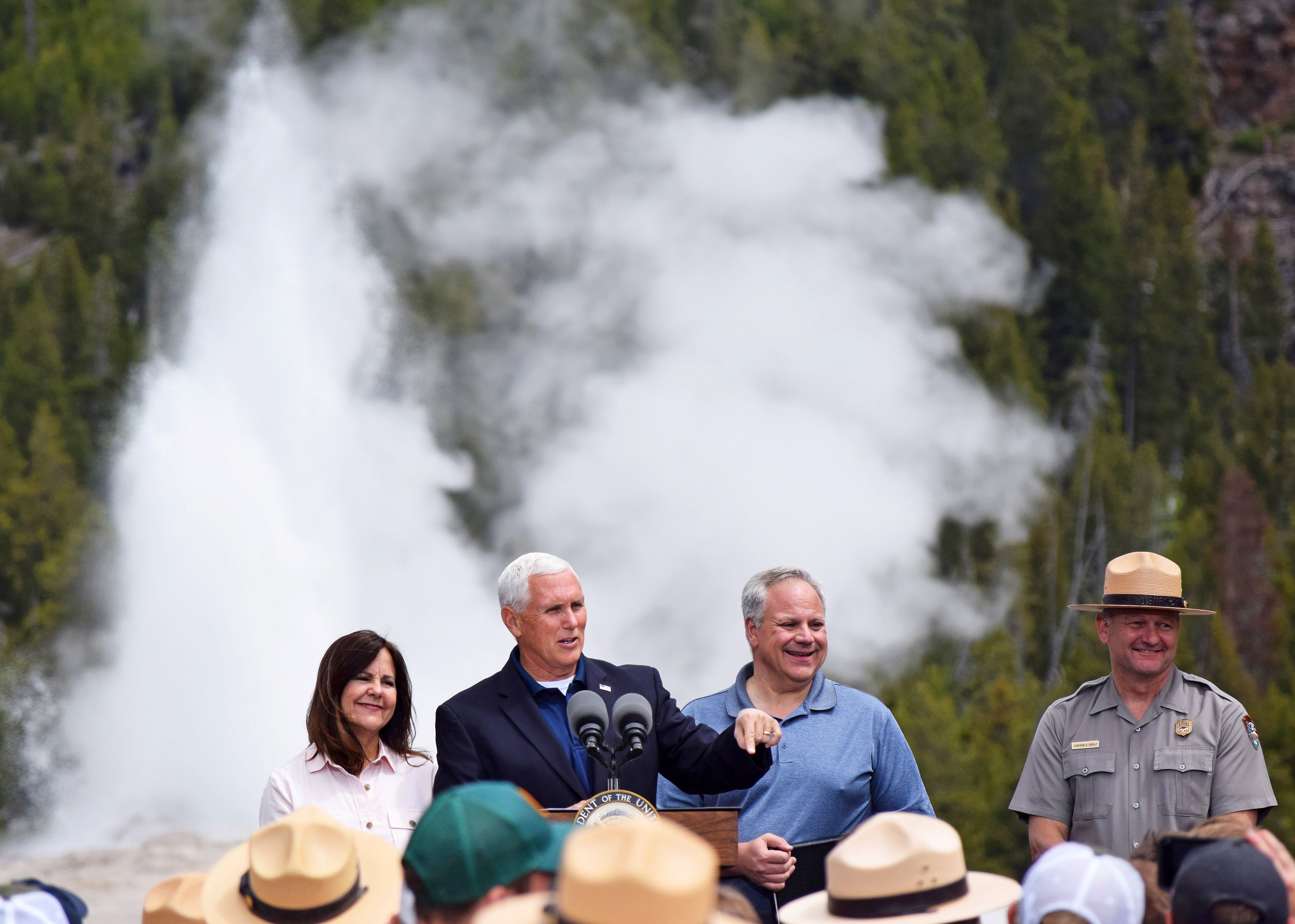 U.S. Vice President Mike Pence, flanked by wife Karen, Interior Secretary David Bernhardt and Yellowstone National Park Superintendent Cam Sholly, speaks in front of Old Faithful Geyser in Yellowstone National Park