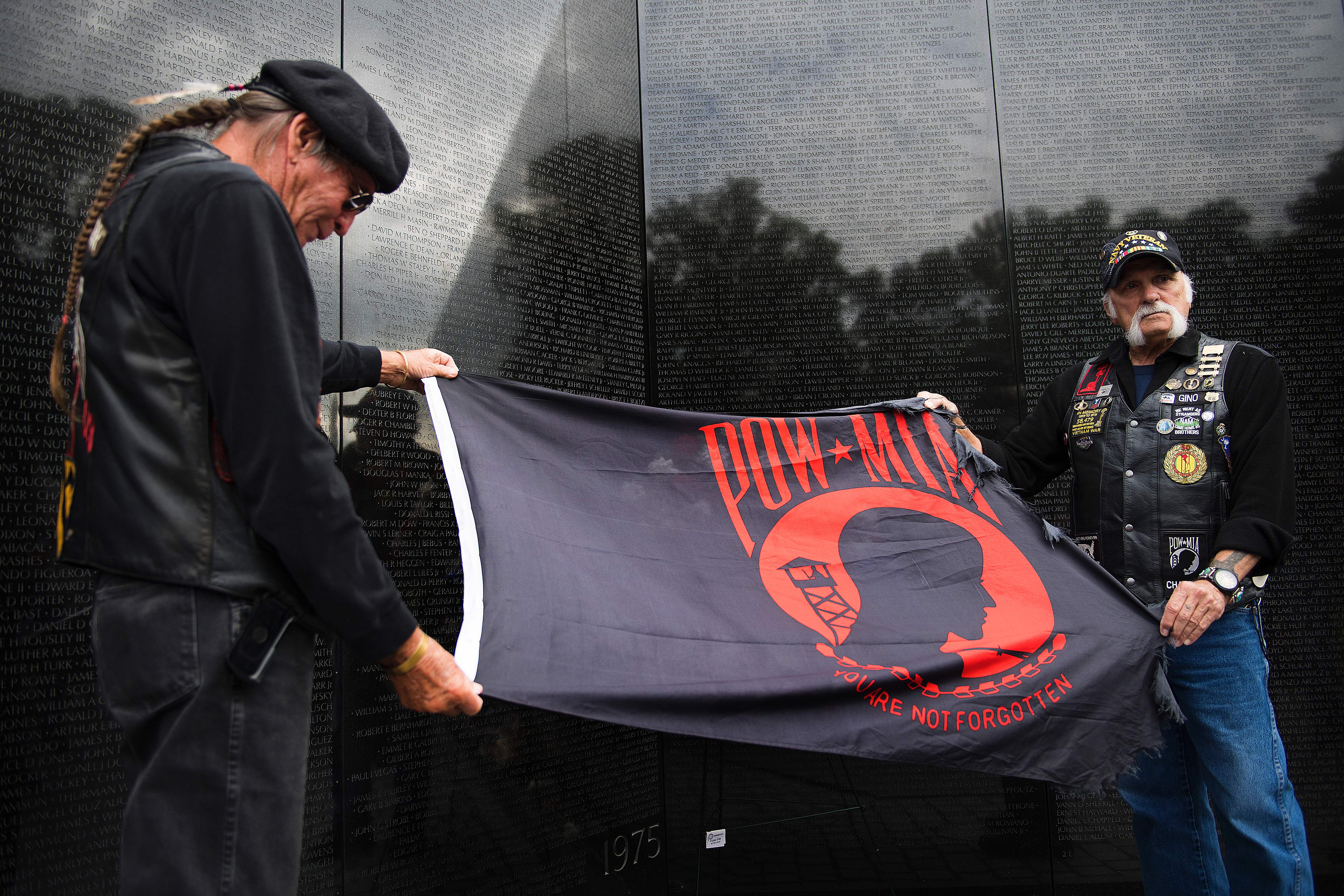 Vietnam veterans Michael Douglas and Gino Del Buono lay a prisoner of war - missing in action (POW - MIA) flag at the wall of Vietnam War Memorial. (Jim Watson/AFP/Getty Images)
