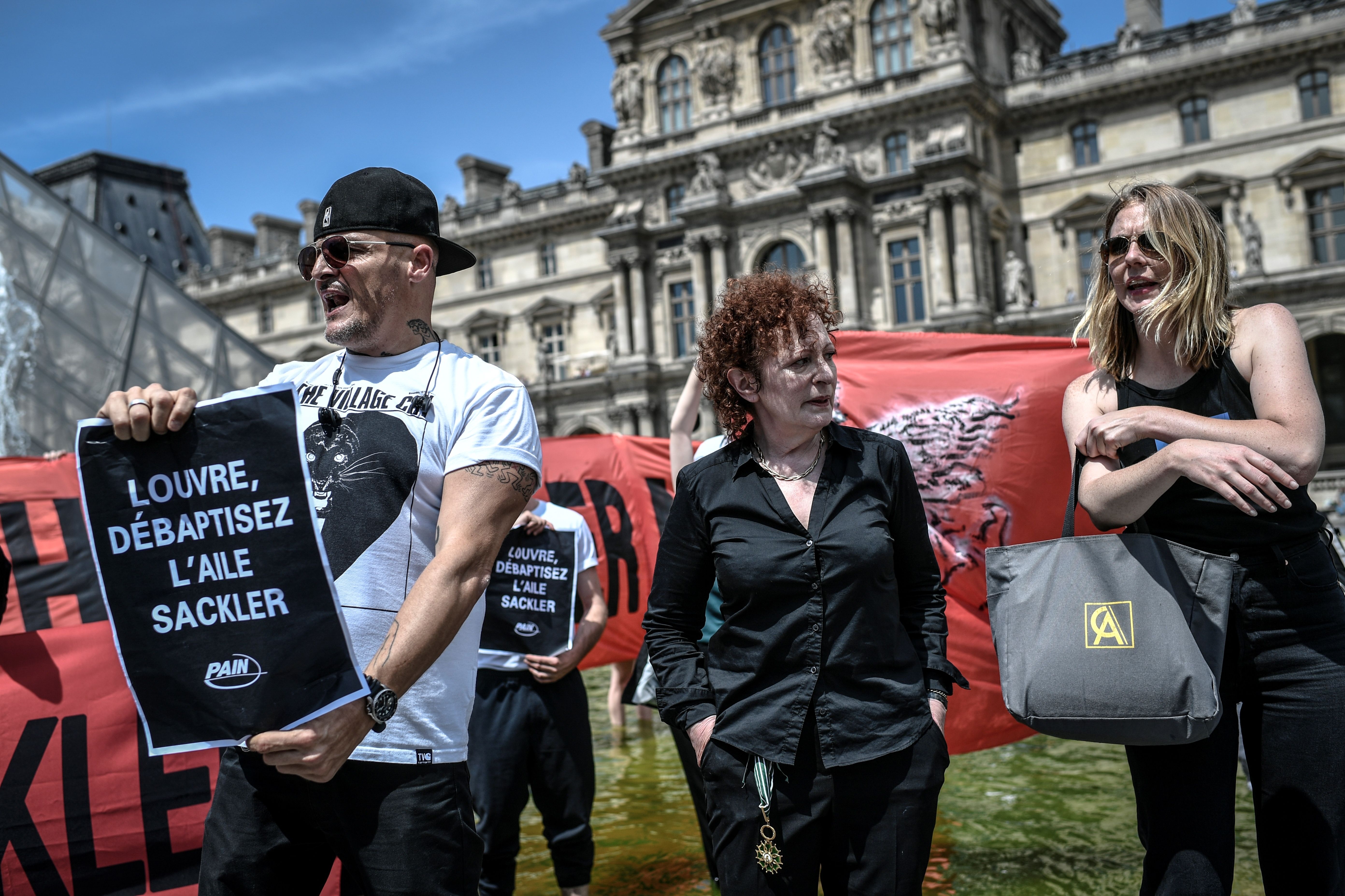 Nancy Goldin (C), photographer and founder of P.A.I.N. (Prescription Addiction Intervention Now) association - created to respond to the opioid crisis - and Fred Bladou (L), mission head of French NGO Aides, take part in a protest on July 1, 2019 in front of the Louvre museum in Paris, to condemn the museum's ties with the Sackler family, billionaire donors accused of pushing to sell a highly addictive painkiller blamed for tens of thousands of deaths. (STEPHANE DE SAKUTIN/AFP/Getty Images)