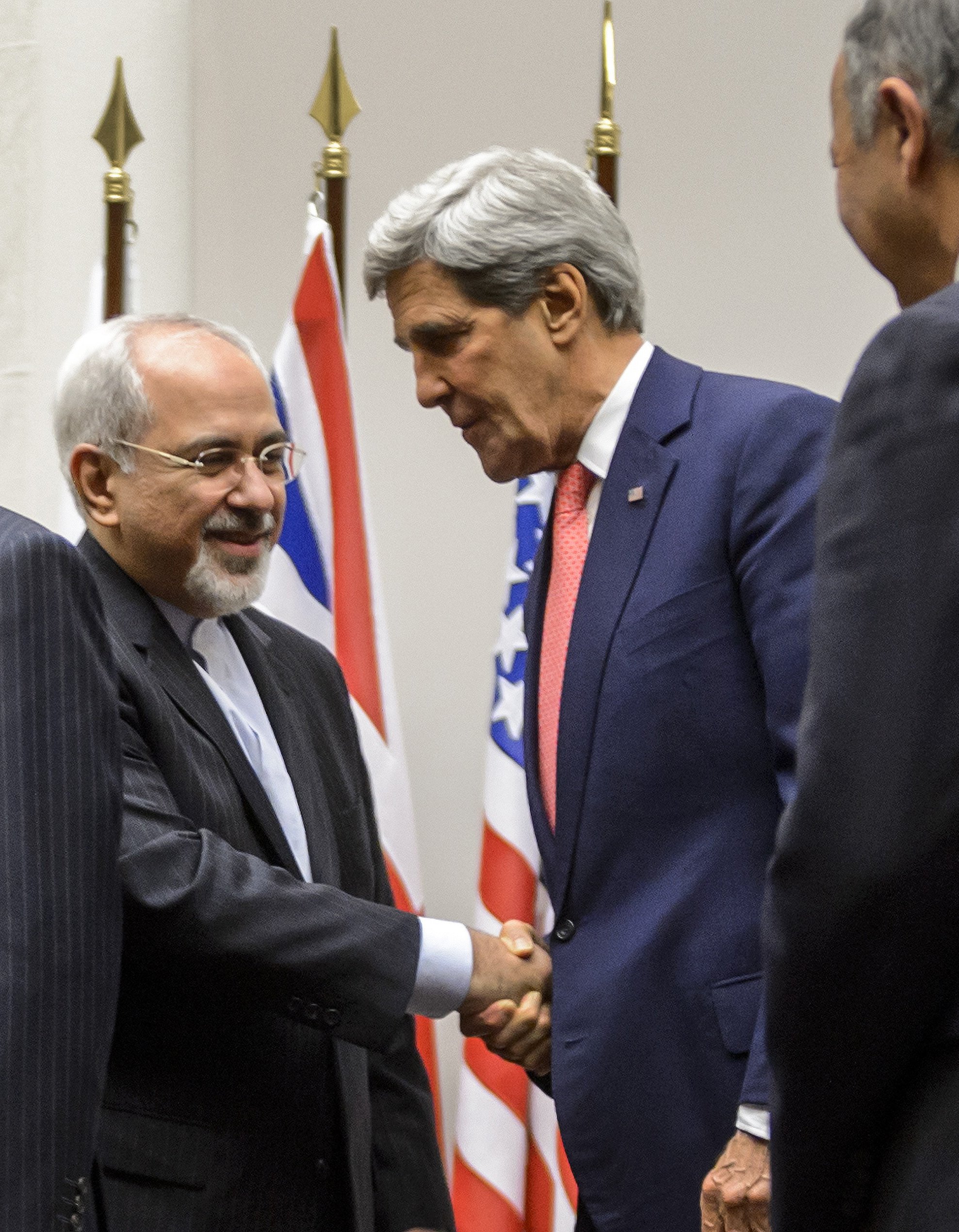 Iranian Foreign Minister Mohammad Javad Zarif (2nd L) shakes hands with US Secretary of State John Kerry as they stand next to French Foreign Minister Laurent Fabius (R) after a statement early on November 24, 2013 in Geneva. (FABRICE COFFRINI/AFP/Getty Images)