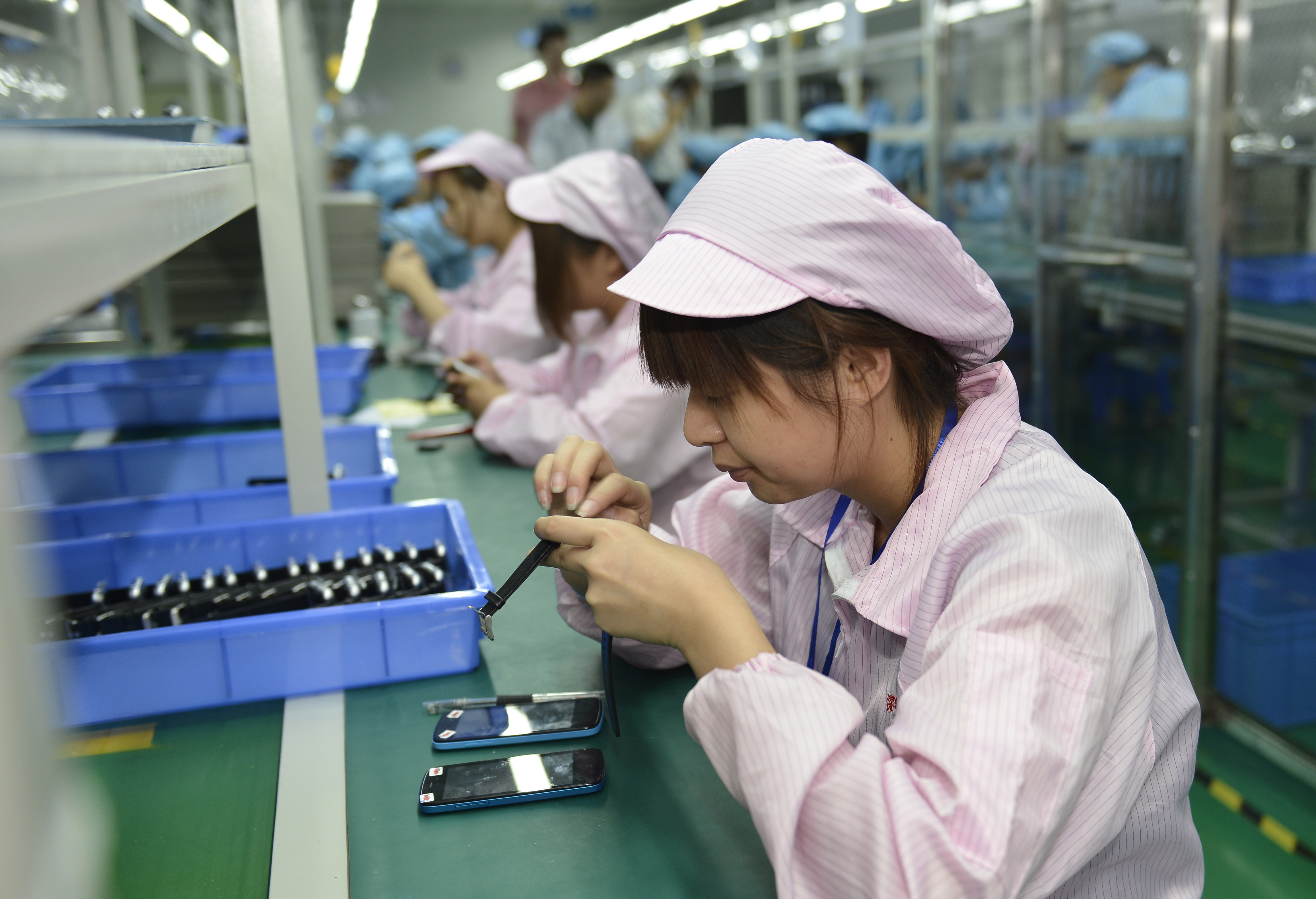Chinese workers assembling a cheaper local alternative to the Apple Watch in a factory producing thousands every day in Shenzhen, in southern China's Guangdong province. (STR/AFP/Getty Images)