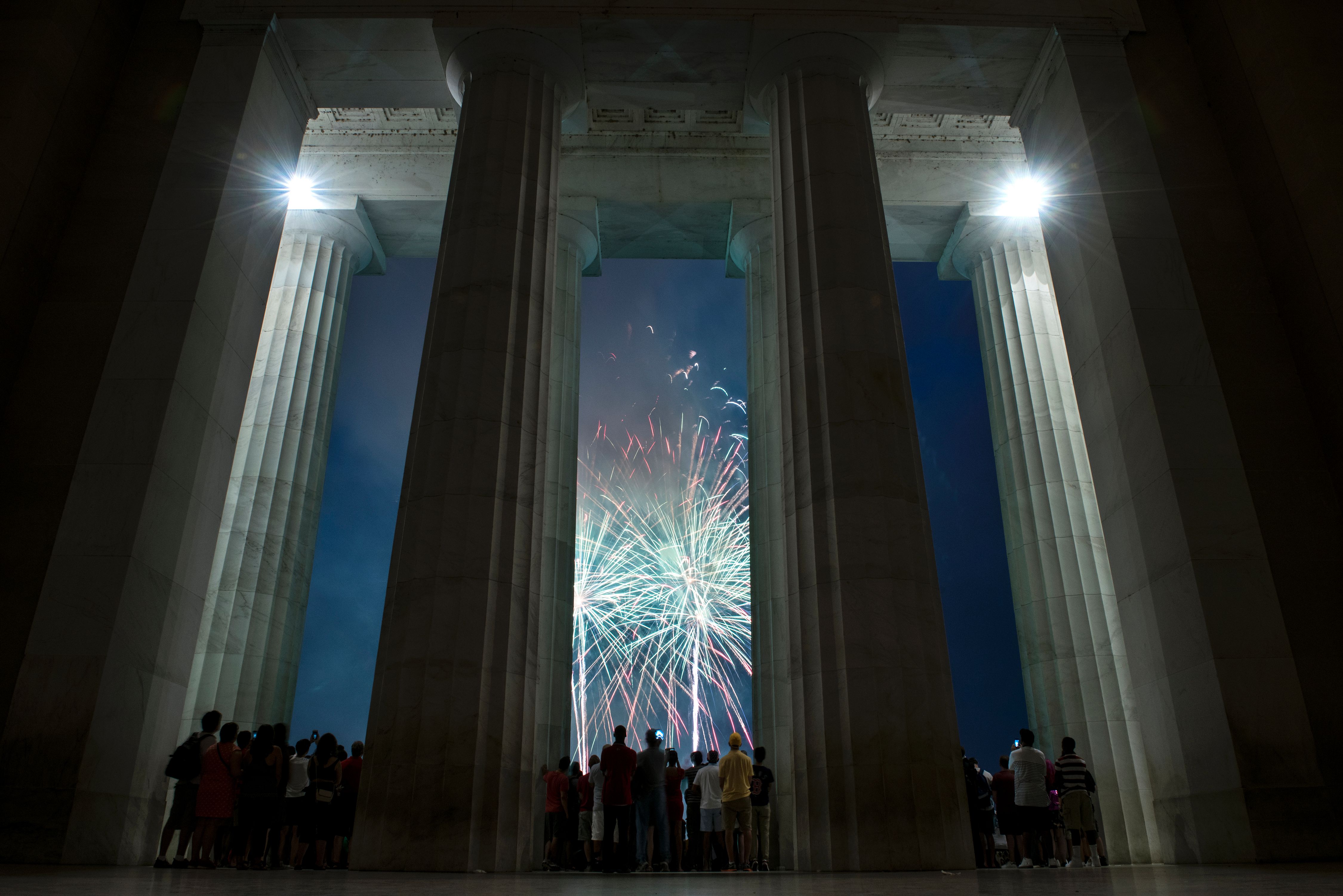 People watch fireworks as they celebrate US independence day on July 4, 2017 in Washington, DC. / AFP PHOTO / Brendan Smialowski (Photo credit should read BRENDAN SMIALOWSKI/AFP/Getty Images)