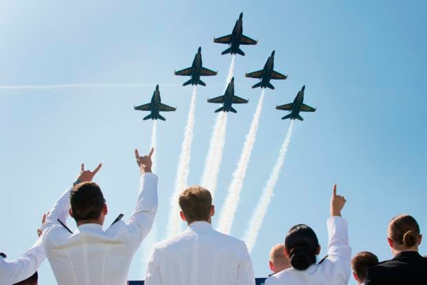 United States Naval Academy midshipmen cheer as the US Navy's Blue Angels fly over the graduation ceremony in Annapolis, Maryland, on May 25, 2018. (Photo by JIM WATSON/AFP/Getty Images)