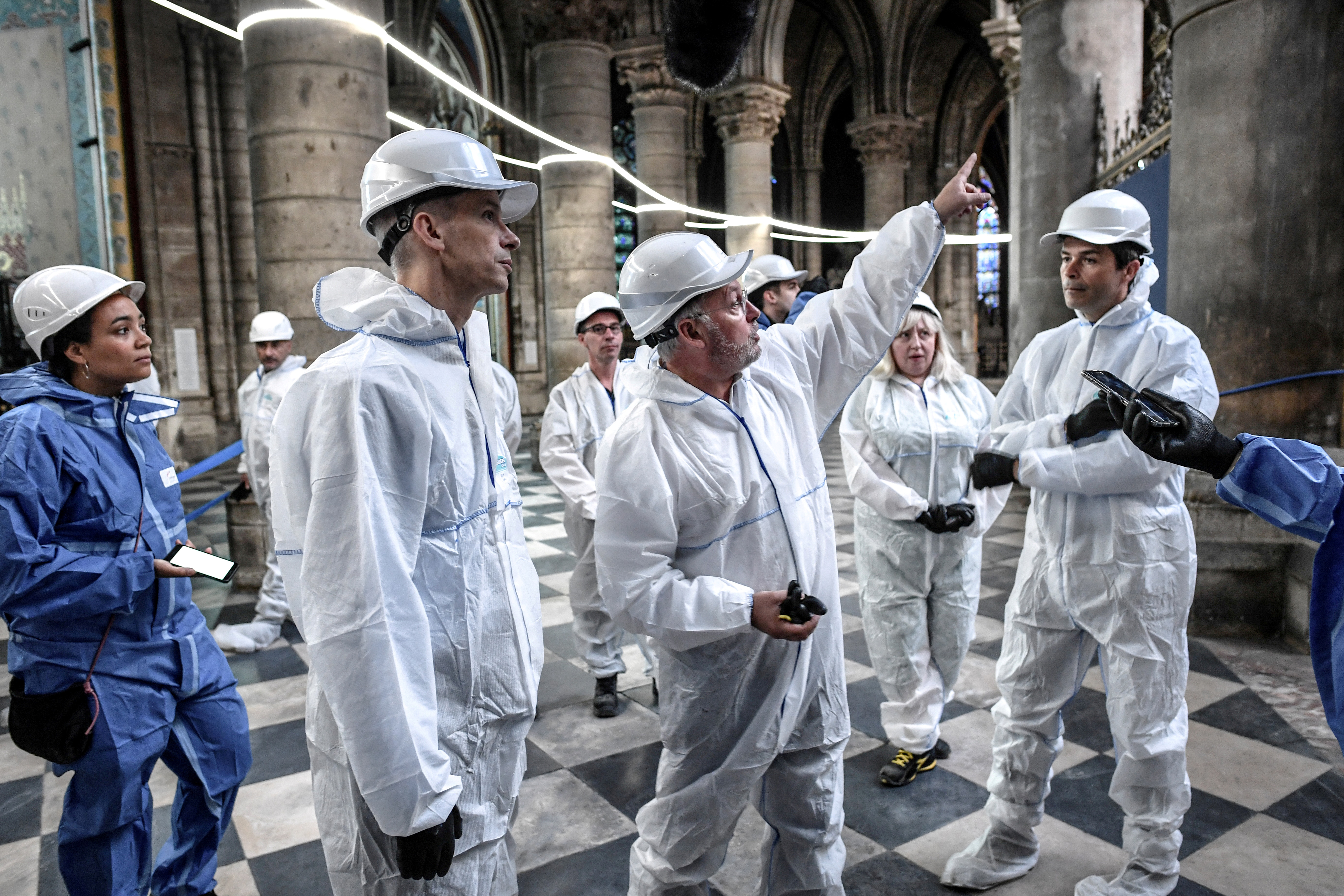 Philippe Villeneuve (pointing) speaks with the French Minister of Culture Franck Riester as they observe the damaged Notre Damme Cathedral. (REUTERS/POOL)