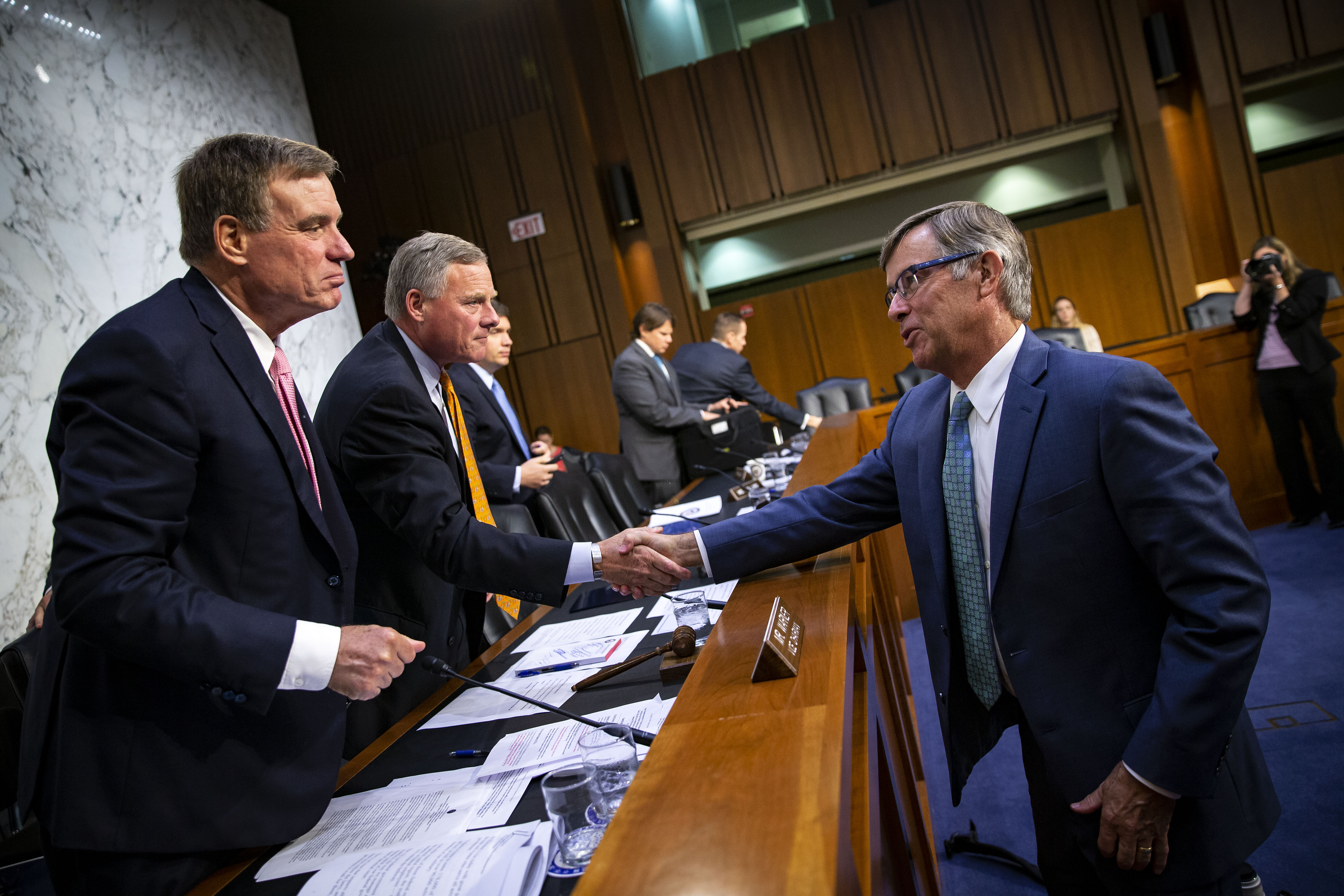 Retired Vice Adm. Joseph Maguire shakes hands with Sen. Richard Burr (R-NC), chairman of the Senate Intelligence Committee, and Sen. Mark Warner (D-VA), vice-chair of the Senate Intelligence Committee. (Photo by Al Drago/Getty Images)