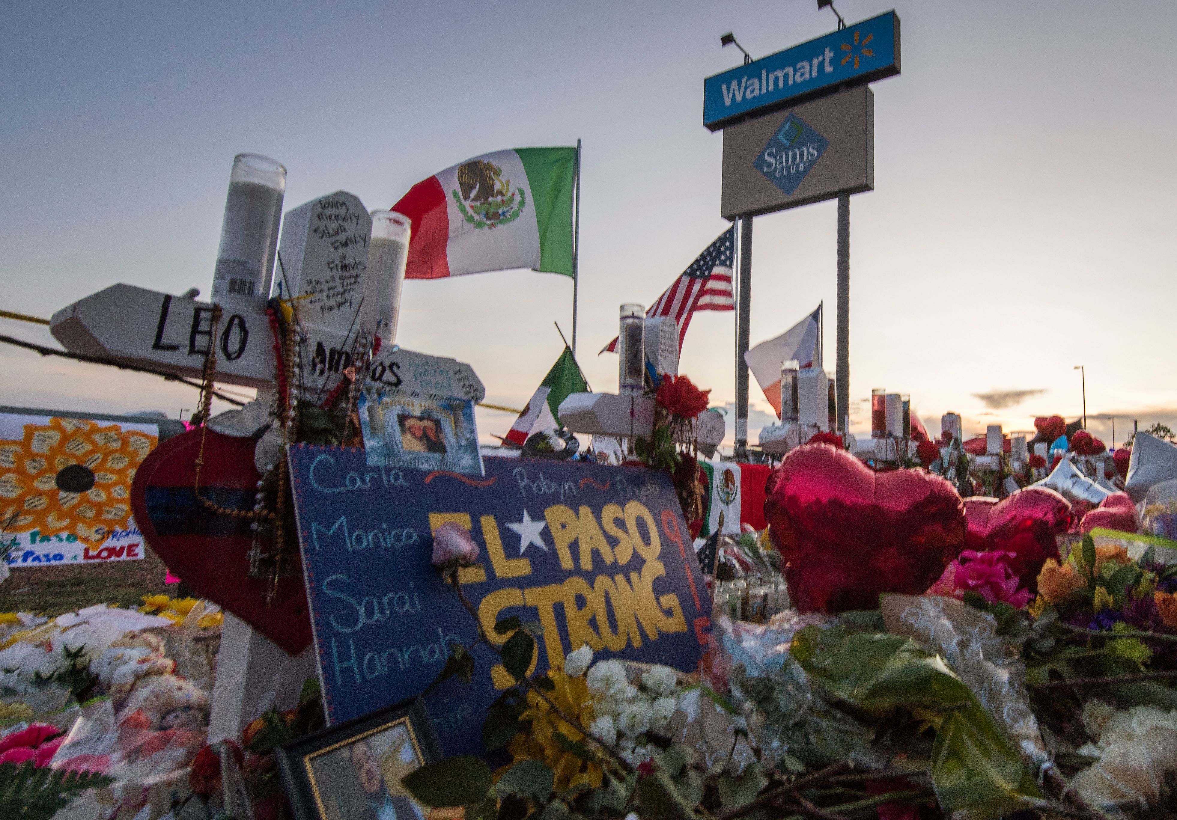 People pray and pay their respects at the makeshift memorial for victims of the shooting that left a total of 22 people dead at the Cielo Vista Mall WalMart (background) in El Paso, Texas, on August 6, 2019 (Mark RALSTON / AFP / Getty Images)