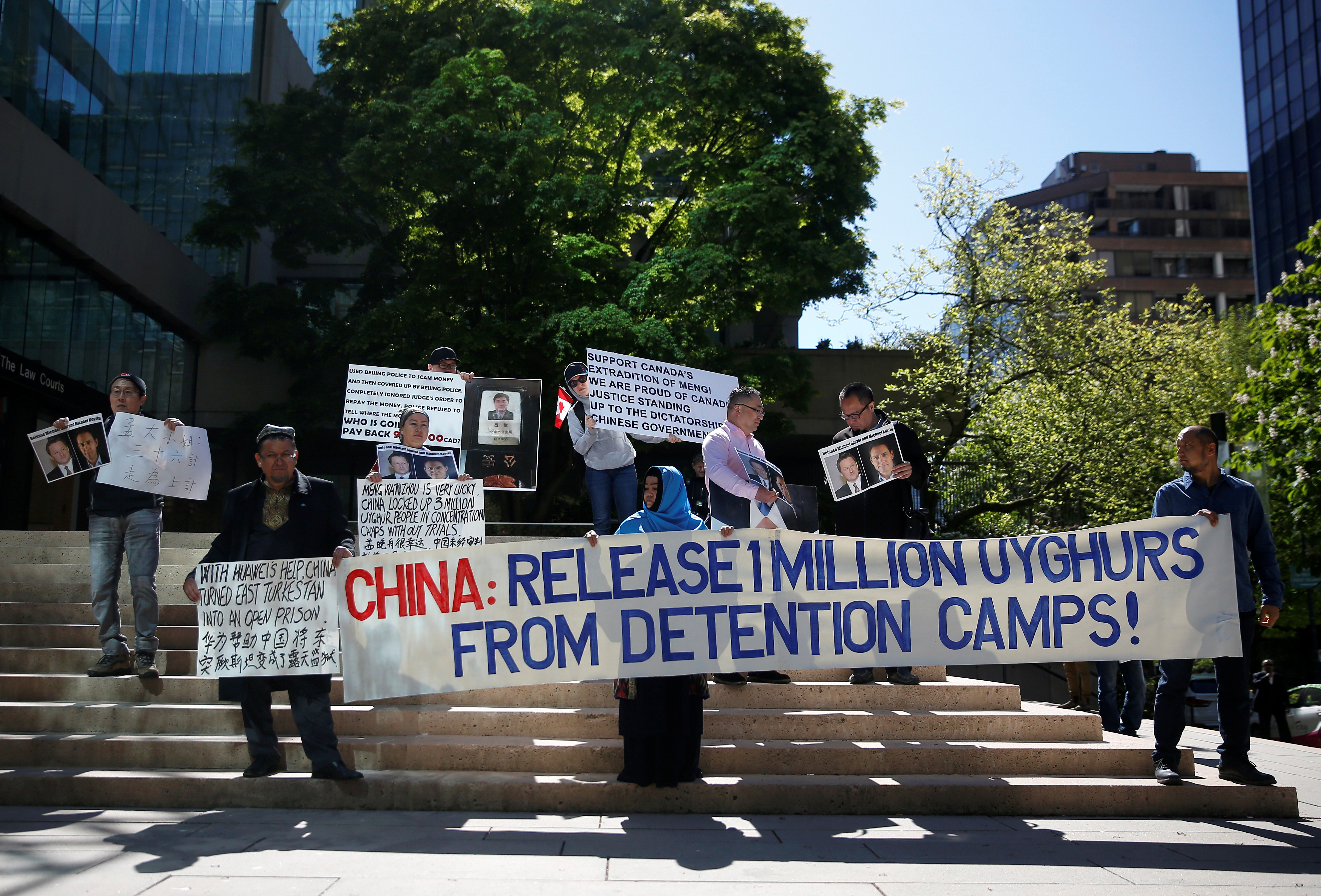 People hold signs protesting China's treatment of the Uighur people during a court appearance by Huawei's Financial Chief Meng Wanzhou, outside of British Columbia Supreme Court building in Vancouver, British Columbia, Canada, May 8, 2019. REUTERS/Lindsey Wasson