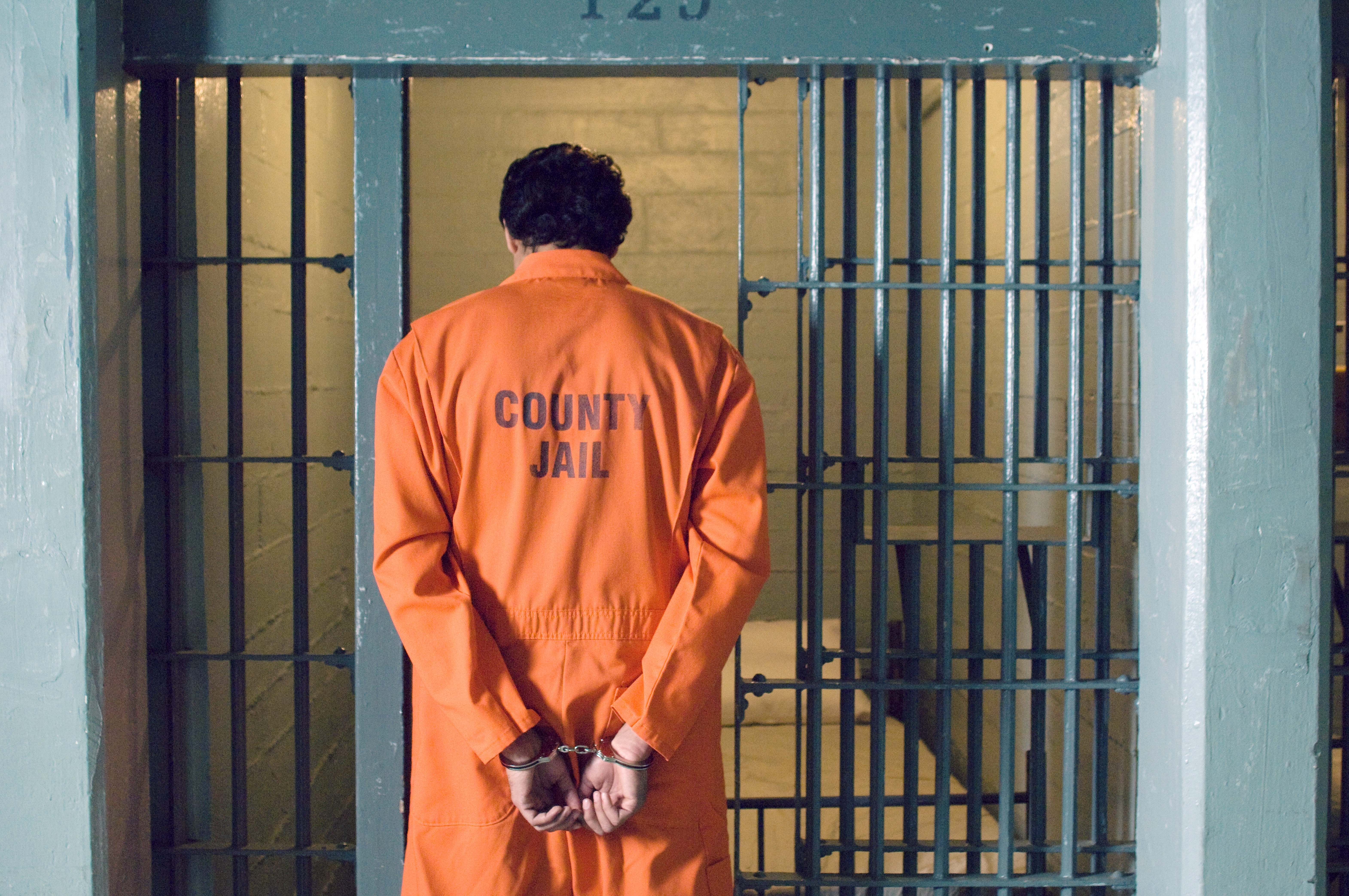 Handcuffed prisoner in jail (sirtravelalot/Shutterstock). 