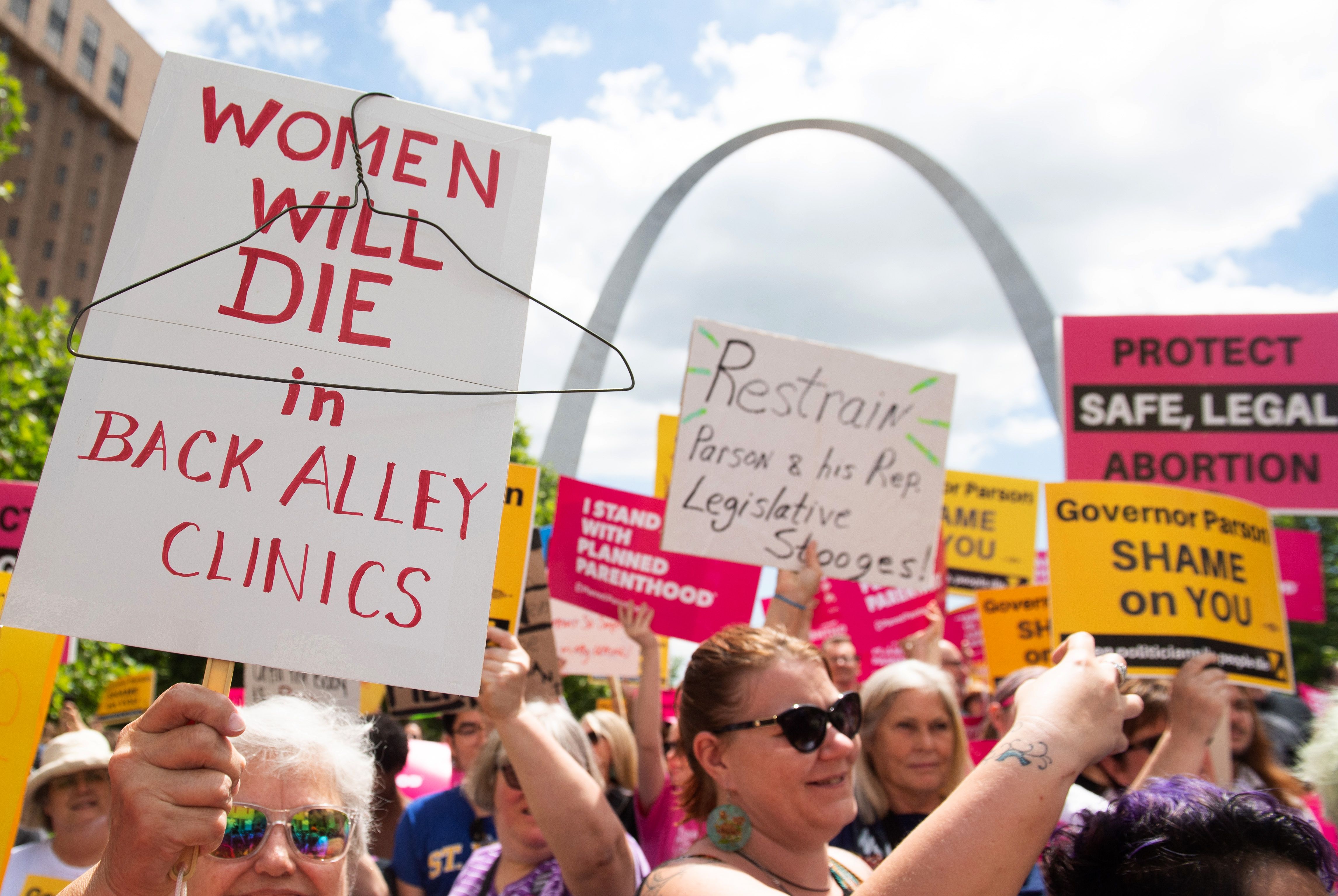 Protesters hold signs as they rally in support of Planned Parenthood and pro-choice and to protest a state decision that would effectively halt abortions by revoking the center's license to perform the procedure, near the Gateway Arch in St. Louis, Missouri, May 30, 2019. (Photo by SAUL LOEB / AFP) 