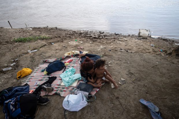 A Honduran woman and her daughter await in Tecun Uman, Guatemala, to cross to Ciudad Hidalgo, Mexico, on June 7, 2019. - The United States warned Friday that President Donald Trump's punitive tariffs on imports from Mexico were on course to take effect next week, despite headway in talks on stemming the surge in migration towards the US border. (Photo by PEDRO PARDO/AFP/Getty Images)