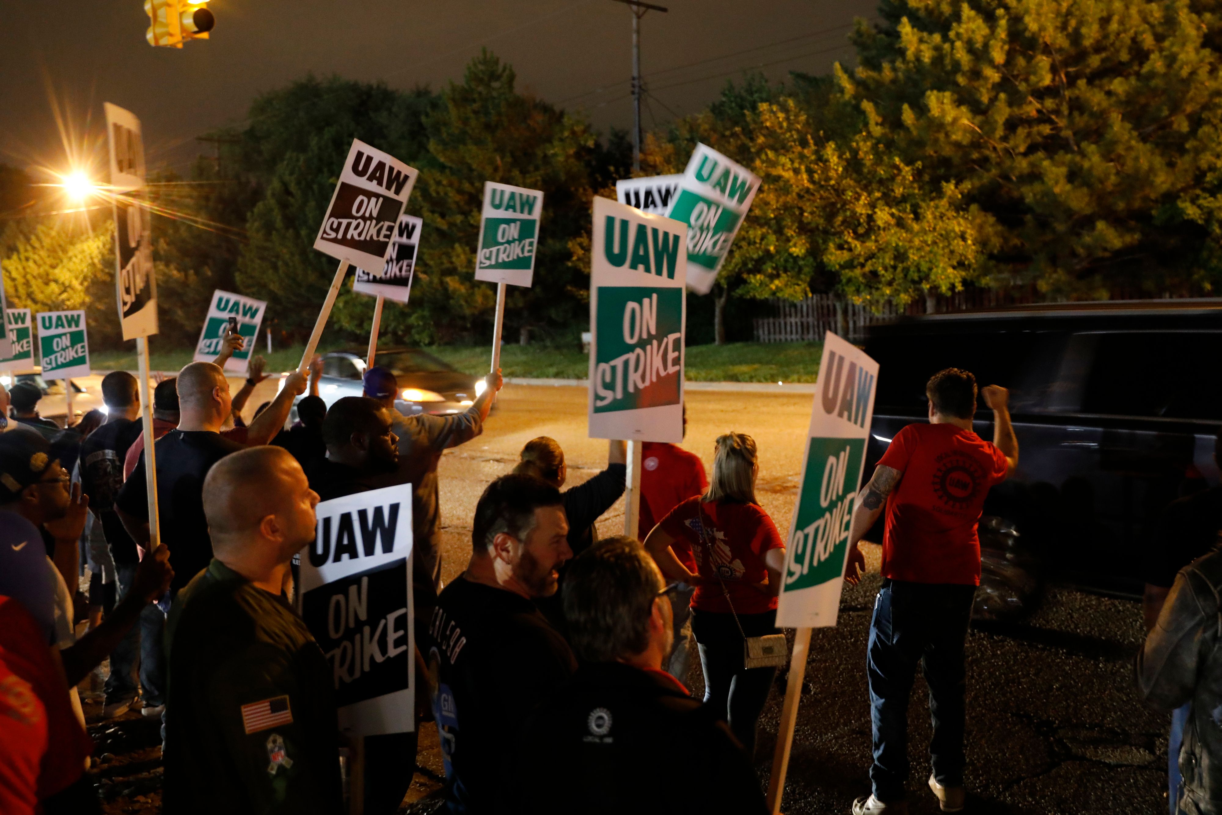 Members of the United Auto Workers (UAW) who are employed at the General Motors Co. Flint Assembly plant in Flint, Michigan, hold signs and cheer as workers drive out of the plant as they go on strike early on September 16, 2019. - The United Auto Workers union began a nationwide strike against General Motors on September 16, with some 46,000 members walking off the job after contract talks hit an impasse. (Photo by JEFF KOWALSKY / AFP) (Photo credit should read JEFF KOWALSKY/AFP/Getty Images)