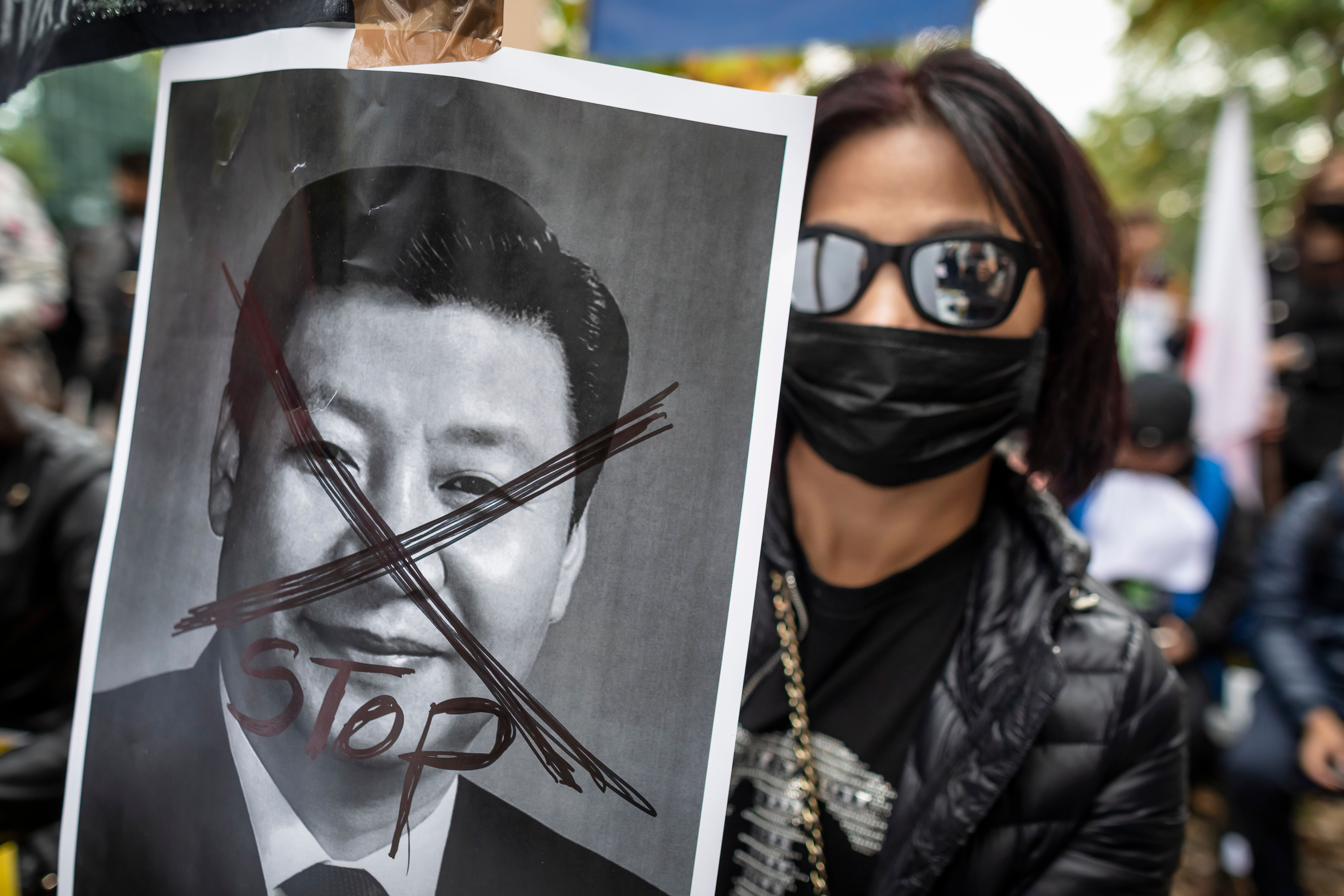 A protestor holds a portrait of Xi Jinping - General Secretary of the Communist Party of China as they demonstrate in front of China embassy in Warsaw in support of pro democracy protests in Hong Kong, September 29, 2019. (Photo by Wojtek RADWANSKI / AFP) (Photo credit should read WOJTEK RADWANSKI/AFP/Getty Images)