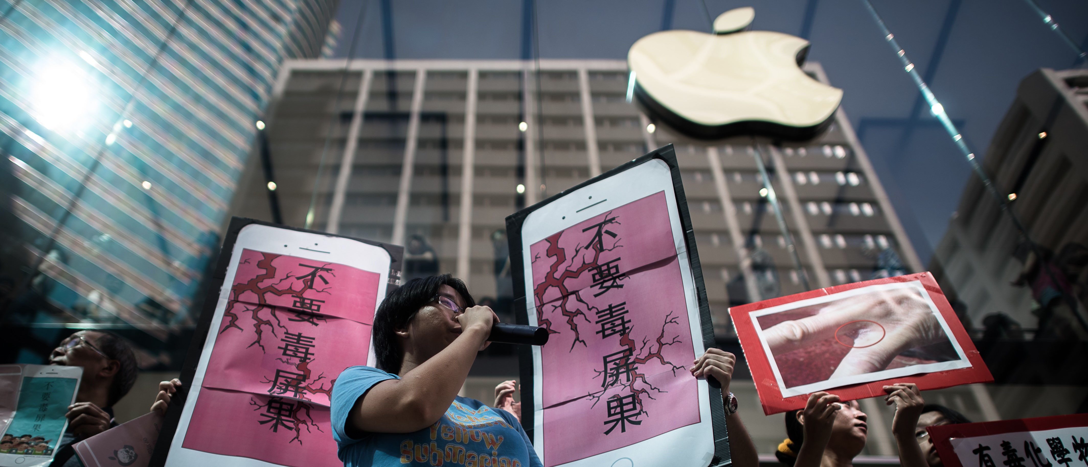Rights campaigners stage a protest coinciding with the launch of the new iPhone 6s outside an Apple store in Hong Kong on September 25, 2015. Apple was urged to act as rights campaigners said a Chinese touchscreen glass supplier to the smartphone giant was exploiting factory workers. AFP PHOTO / Philippe Lopez /Getty Images