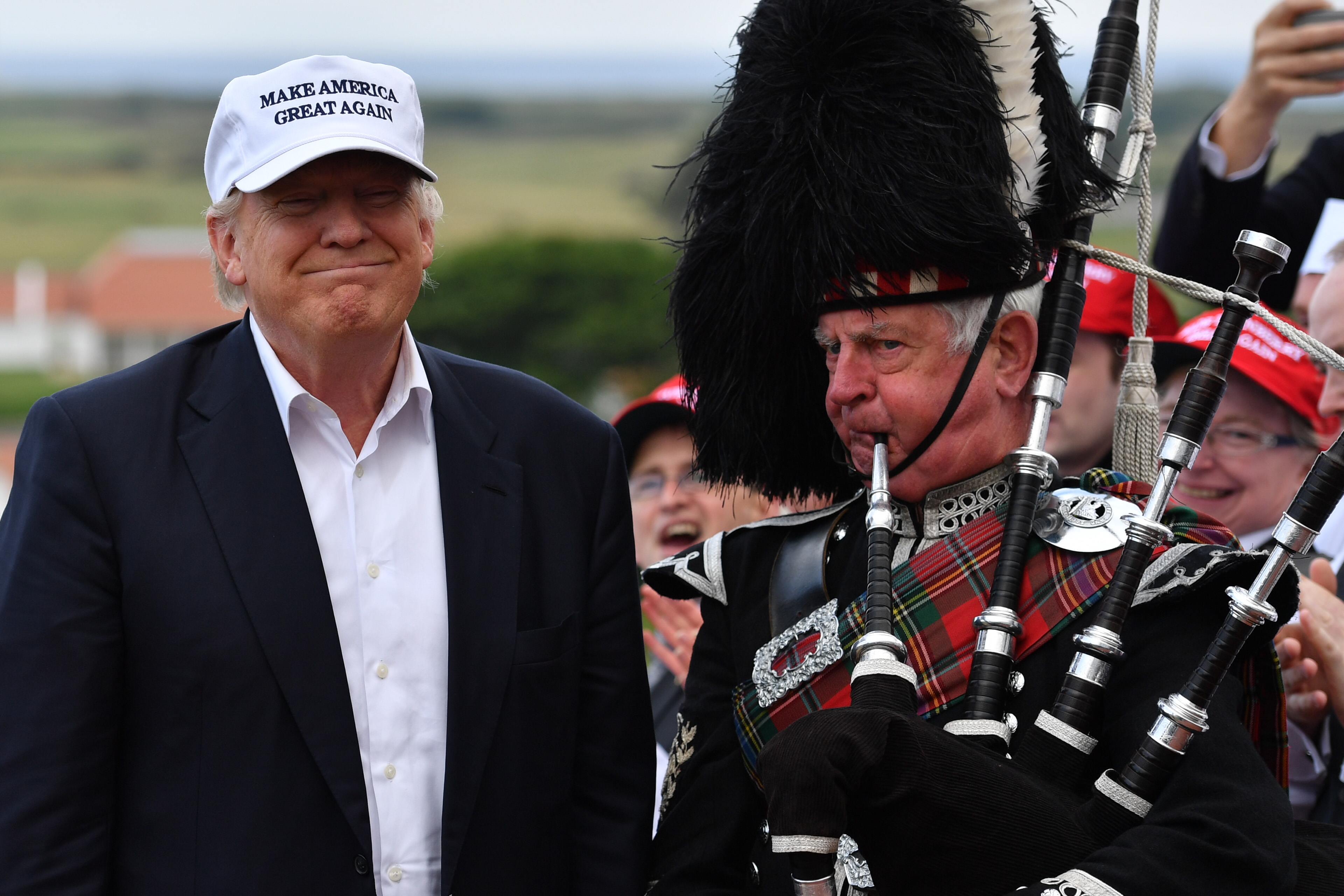 AYR, SCOTLAND - JUNE 24: A bagpipe player wears traditional dress next to Presumptive Republican nominee for US president Donald Trump as he arrives to his Trump Turnberry Resort on June 24, 2016 in Ayr, Scotland. Mr Trump arrived to officially open his golf resort which has undergone an eight month refurbishment as part of an investment thought to be worth in the region of two hundred million pounds. (Photo by Jeff J Mitchell/Getty Images)