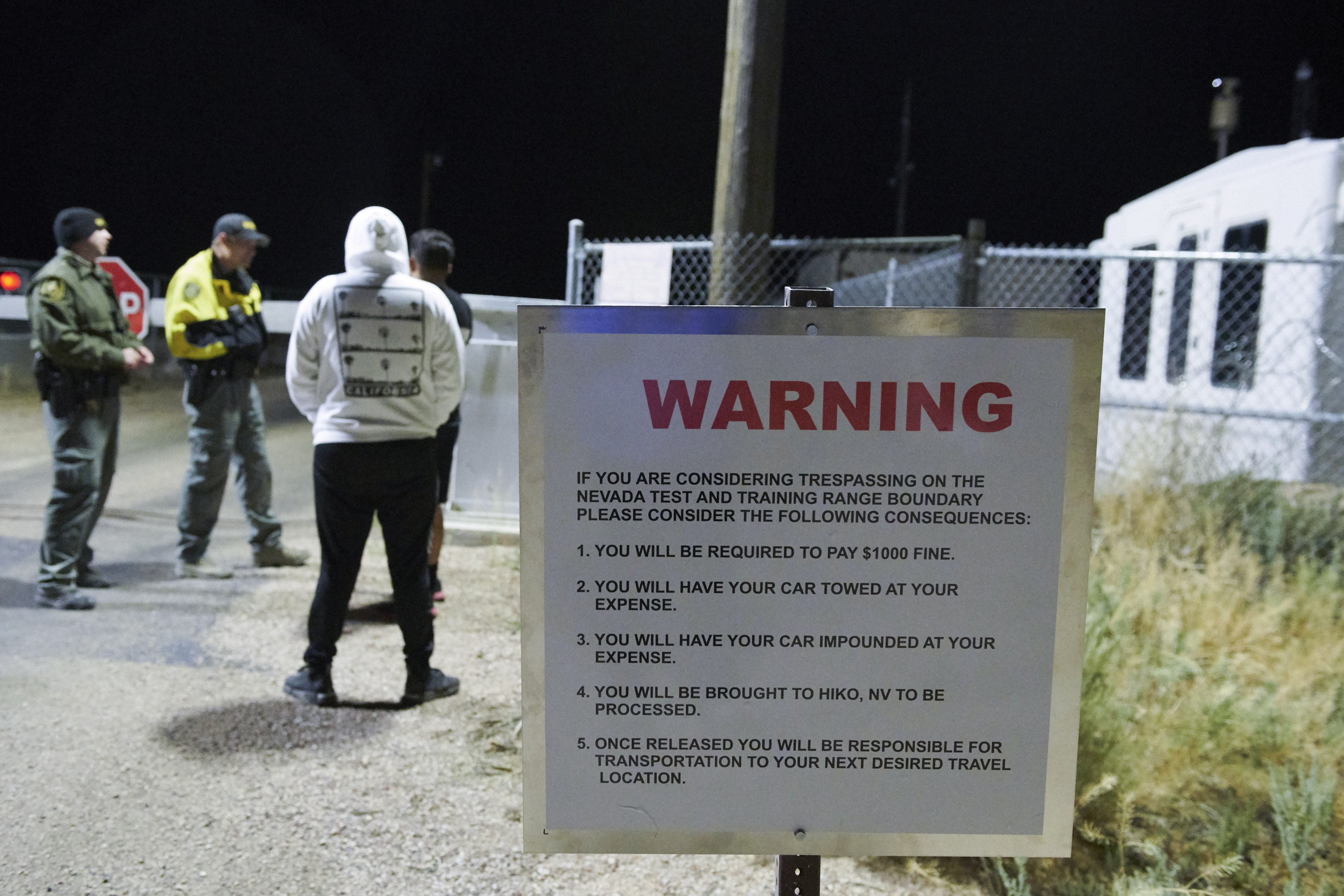 Attendees discuss with guards as they gather to "storm" Area 51 at an entrance to the military facility near Rachel, Nevada on September 20, 2019. (Photo by BRIDGET BENNETT/AFP/Getty Images)