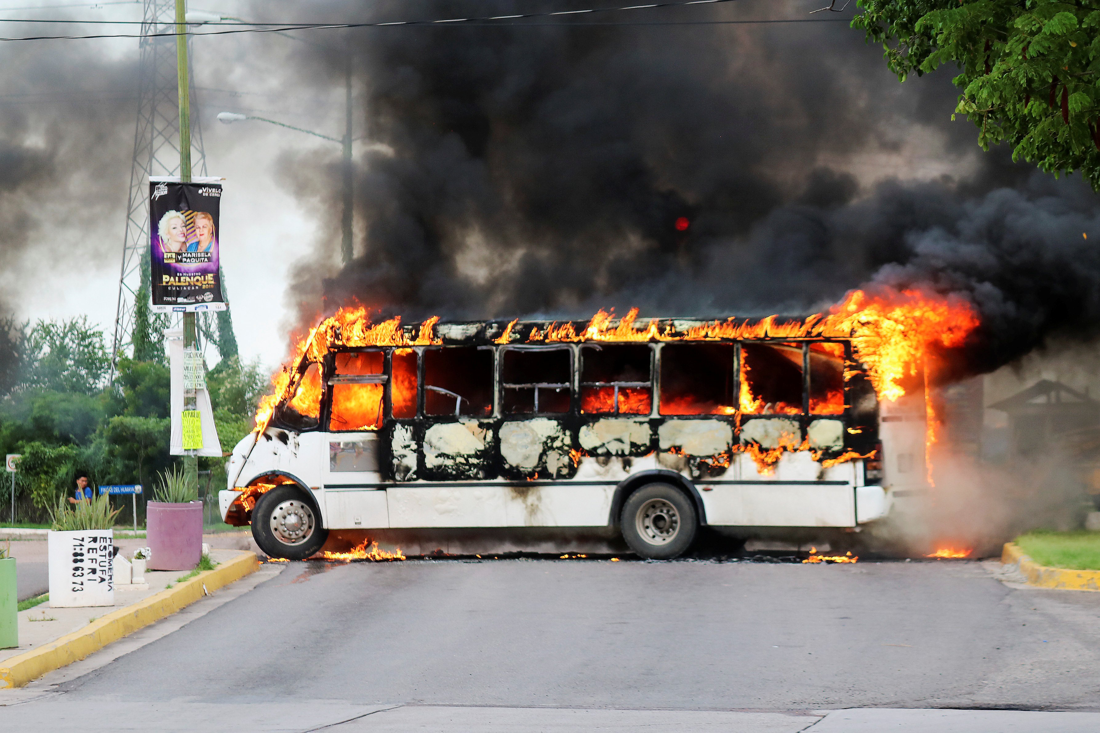 A burning bus, set alight by cartel gunmen to block a road, is pictured during clashes with federal forces following the detention of Ovidio Guzman, son of drug kingpin Joaquin "El Chapo" Guzman, in Culiacan