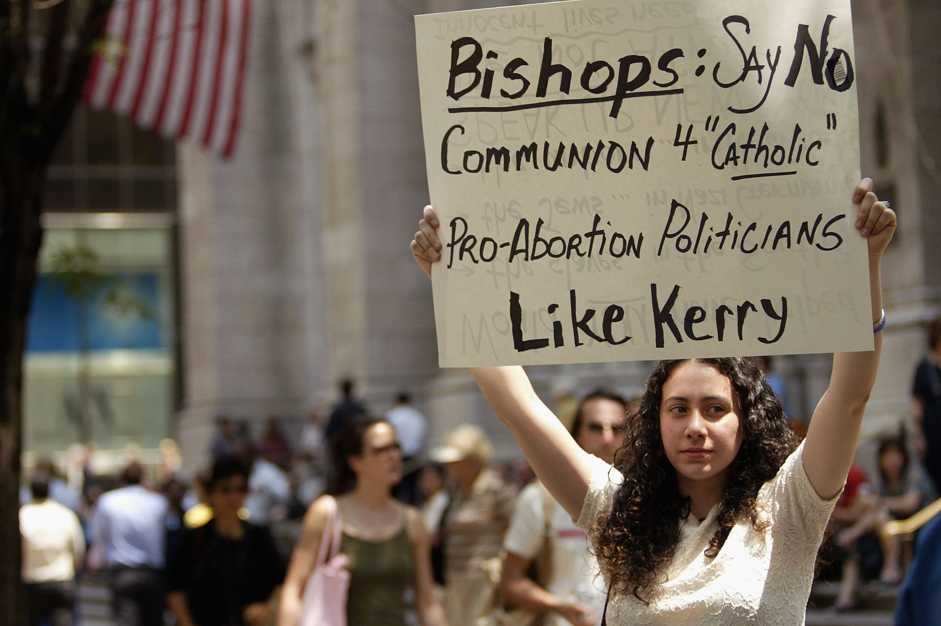 NEW YORK - JUNE 16: Jenni Logan holds up a sign urging presumptive Democratic presidential nominee John Kerry to be denied Holy Communion in front of St. Patrick's Cathedral June16, 2004 in New York City. Some bishops around the country are urging Kerry, a pro-choice Catholic, and other pro-choice Catholic politicians to abstain voluntarily from taking Communion. (Photo by Spencer Platt/Getty Images)