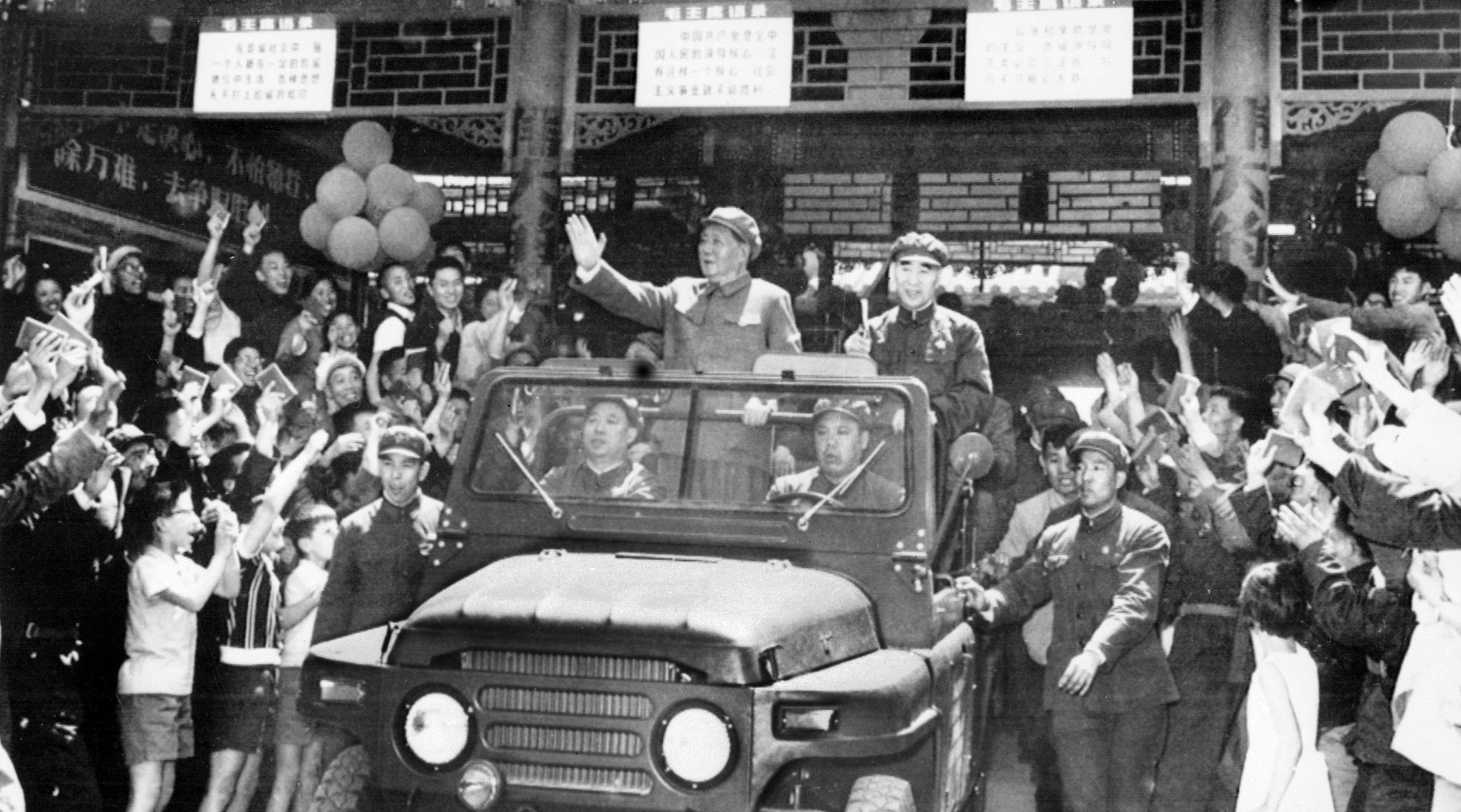 BEIJING, CHINA: From left: Mao Zedong (1893-1976), leading theorist of the Chinese communist revolution, chairman of the party and President of the Republic, and Lin Piao (1907-71), minister of defense and supporter of the Cultural revolution, wave 01 May 1967 from a convertible jeep to the cheering crowd at Tiananmen Square in Beijing as they celebrate May Day. (Photo credit should read AFP via Getty Images)