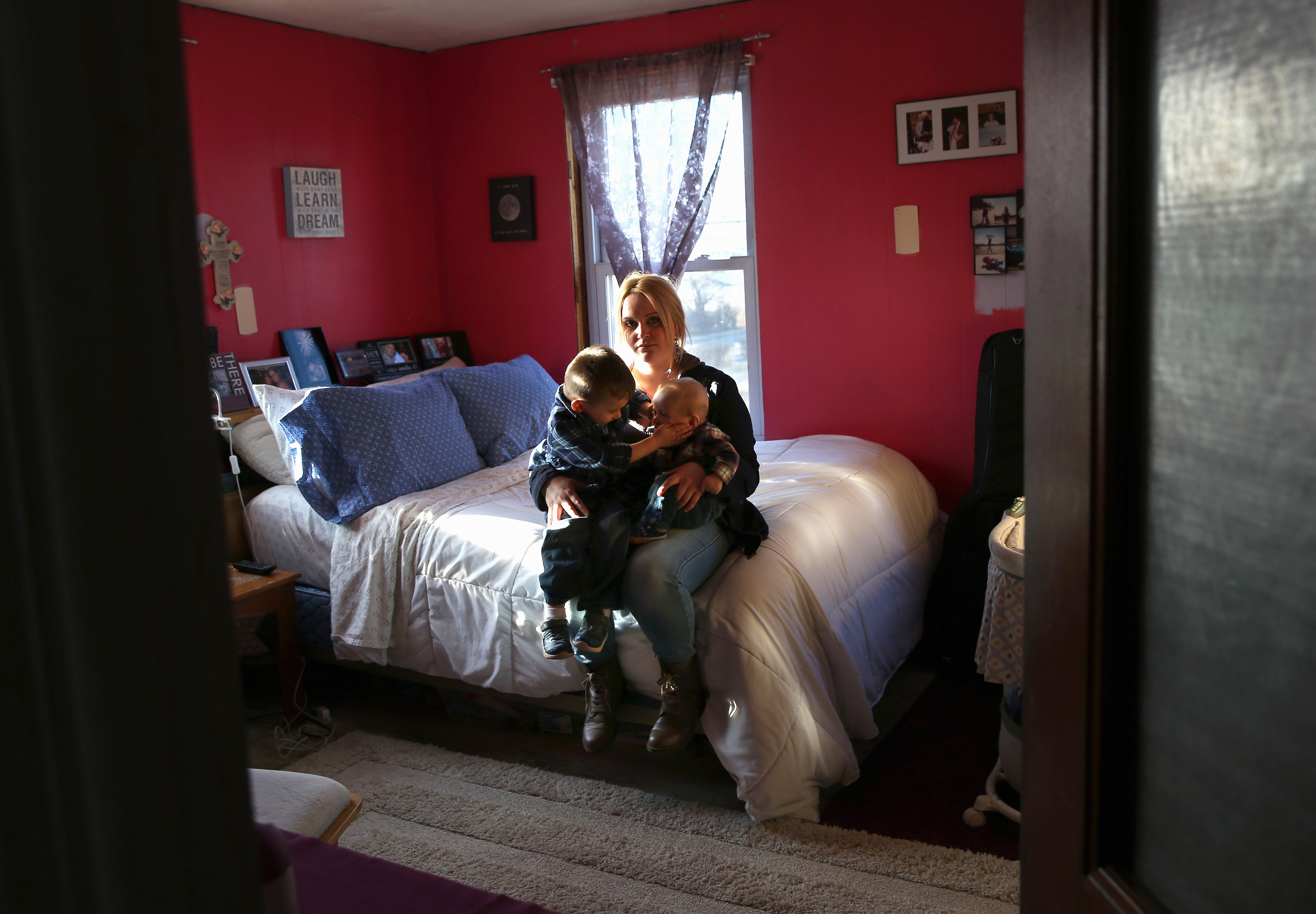 Hillary Comparone, 25, holds her children Cameron Comparone, 2 1/2 years, and Lincoln, 4 1/2 months, in her bedroom on March 6, 2016 in Plainville, Connecticut while marking the first anniversary of the death of the children's father Benjamin Comparone, 27, who died of heroin overdose. (Photo by John Moore/Getty Images)