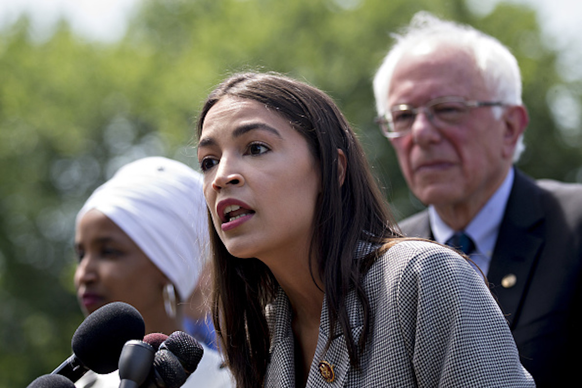 Representative Alexandria Ocasio-Cortez, a Democrat from New York, speaks as Senator Bernie Sanders, an independent from Vermont, right, and Representative Ilhan Omar, a Democrat from Minnesota, left, listen during a news conference announcing college affordability legislation on Capitol Hill in Washington, D.C., U.S., on Monday, June 24, 2019. Sanders is proposing to cancel the nation's outstanding $1.6 trillion of student debt and offsetting the cost with a tax on Wall Street transactions. Photographer: Andrew Harrer/Bloomberg via Getty Images