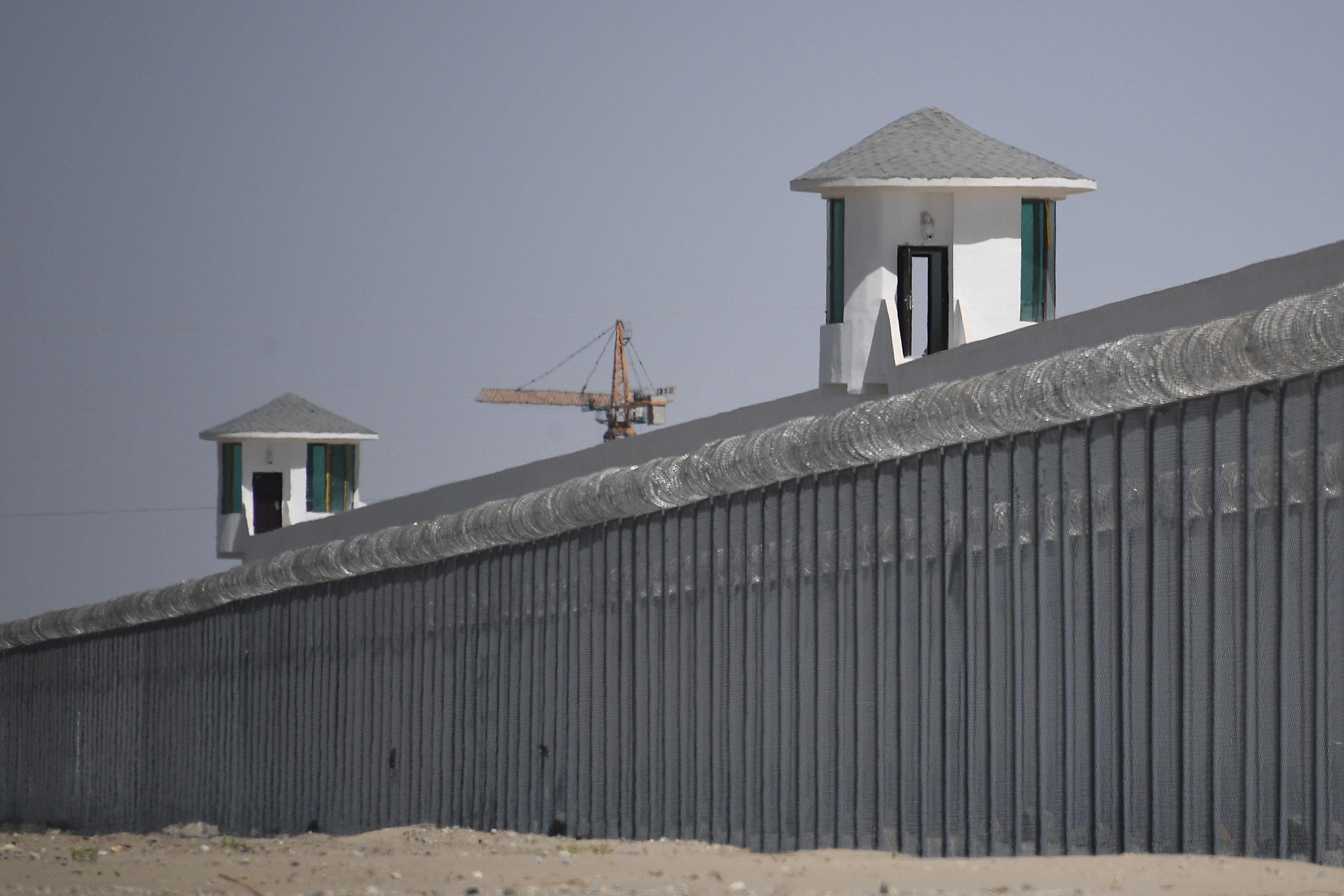 This photo taken on May 31, 2019 shows watchtowers on a high-security facility near what is believed to be a re-education camp where mostly Muslim ethnic minorities are detained, on the outskirts of Hotan, in China's northwestern Xinjiang region. - As many as one million ethnic Uighurs and other mostly Muslim minorities are believed to be held in a network of internment camps in Xinjiang, but China has not given any figures and describes the facilities as "vocational education centres" aimed at steering people away from extremism. (Photo by GREG BAKER / AFP) / TO GO WITH AFP STORY CHINA-XINJIANG-MEDIA-RIGHTS-PRESS,FOCUS BY EVA XIAO (Photo credit should read GREG BAKER/AFP via Getty Images)