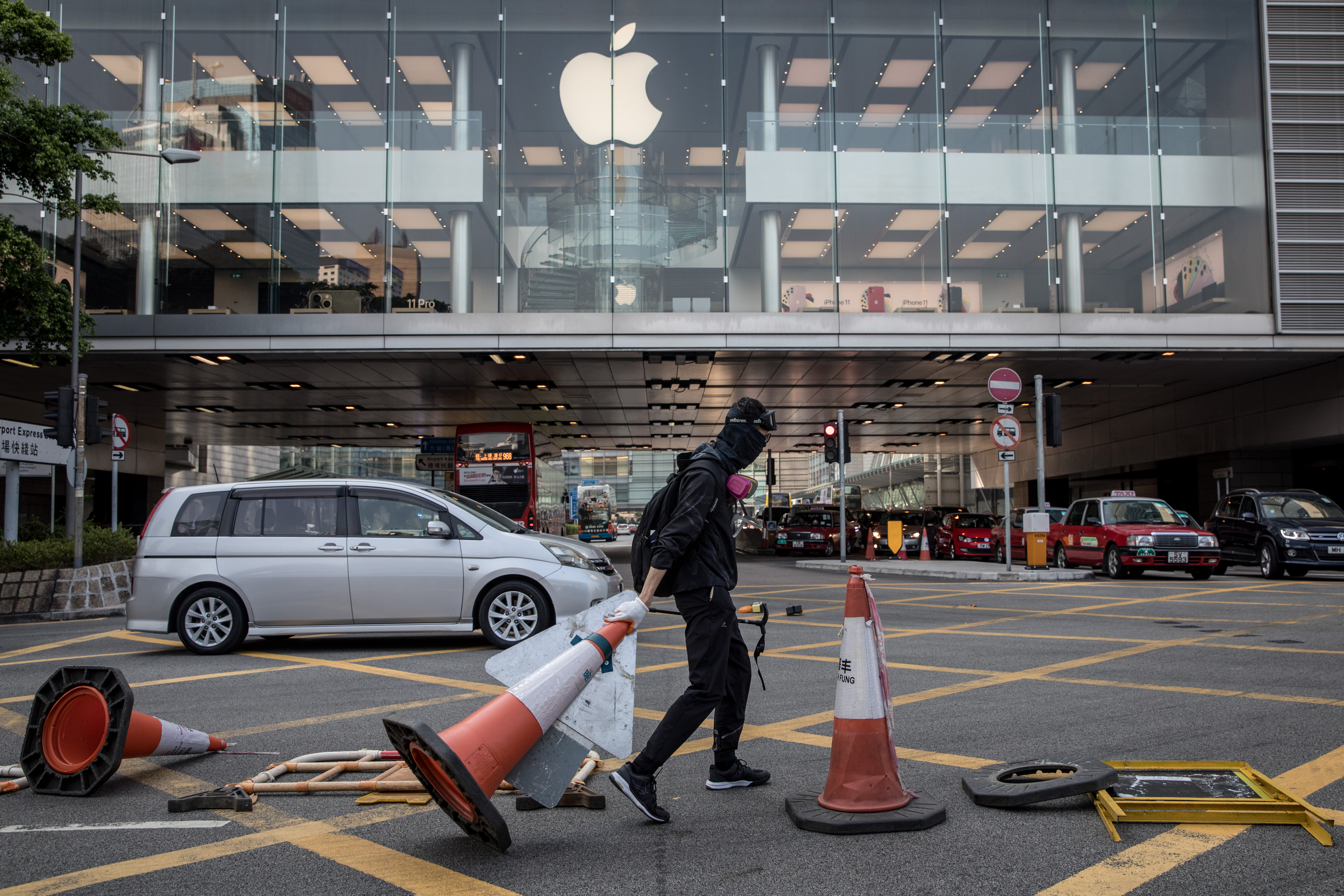 HONG KONG, CHINA - OCTOBER 01: A pro-democracy protester blocks a road outside the Apple store during clashes with police on October 01, 2019 in Hong Kong, China. Pro-democracy protesters marked the 70th anniversary of the founding of the People's Republic of China in Hong Kong through demonstrations as the city remains on the edge with the anti-government movement entering its fourth month. Protesters in Hong Kong continue its call for Chief Executive Carrie Lam to meet their remaining demands since the controversial extradition bill has been withdrawn, which includes an independent inquiry into police brutality, the retraction of the word “riot” to describe the rallies, and genuine universal suffrage, as the territory faces a leadership crisis. (Photo by Chris McGrath/Getty Images)