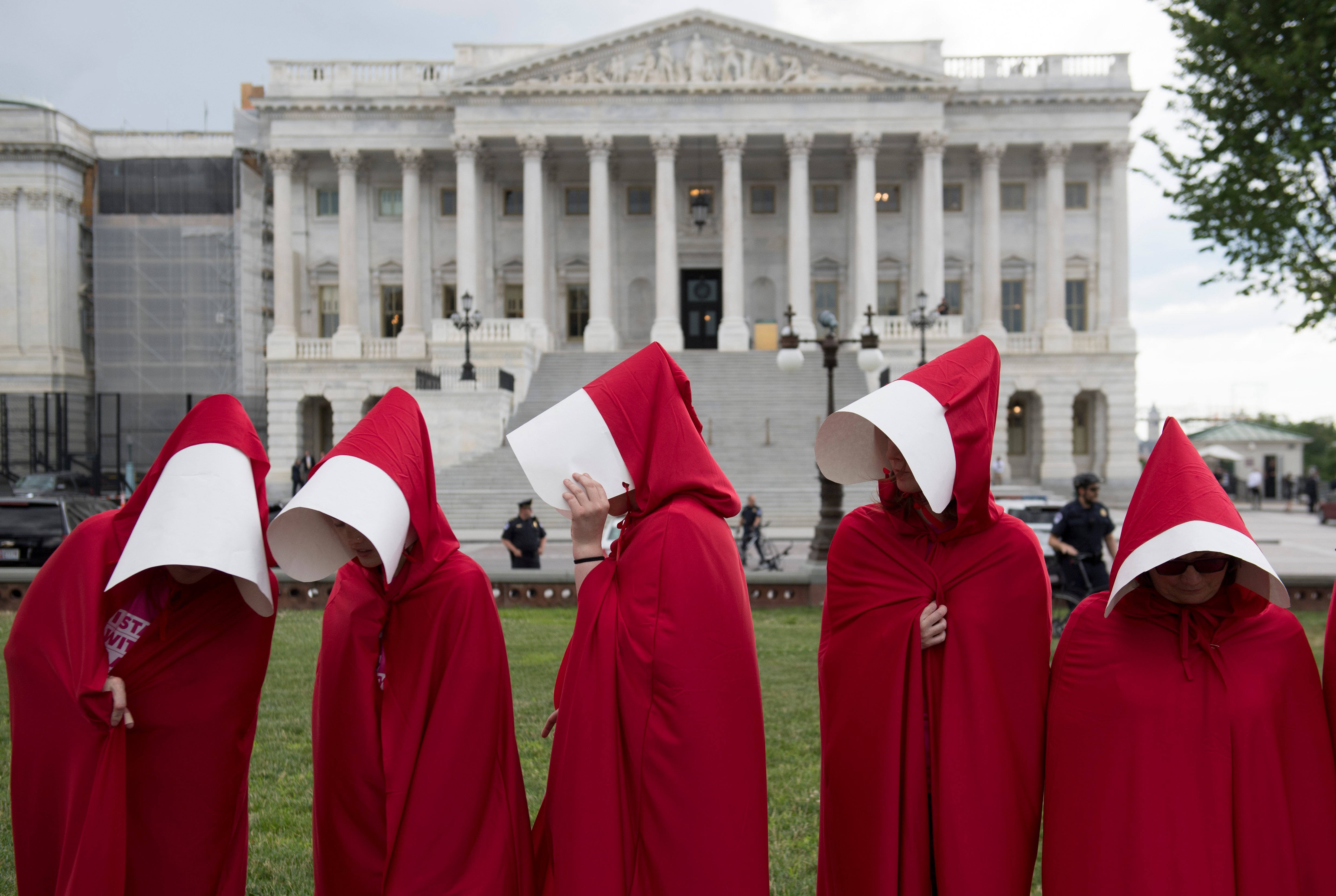 Supporters of Planned Parenthood dressed as characters from "The Handmaid's Tale," hold a rally as they protest the US Senate Republicans' healthcare bill outside the US Capitol in Washington, DC, June 27, 2017. / AFP PHOTO / SAUL LOEB (Photo credit should read SAUL LOEB/AFP via Getty Images)