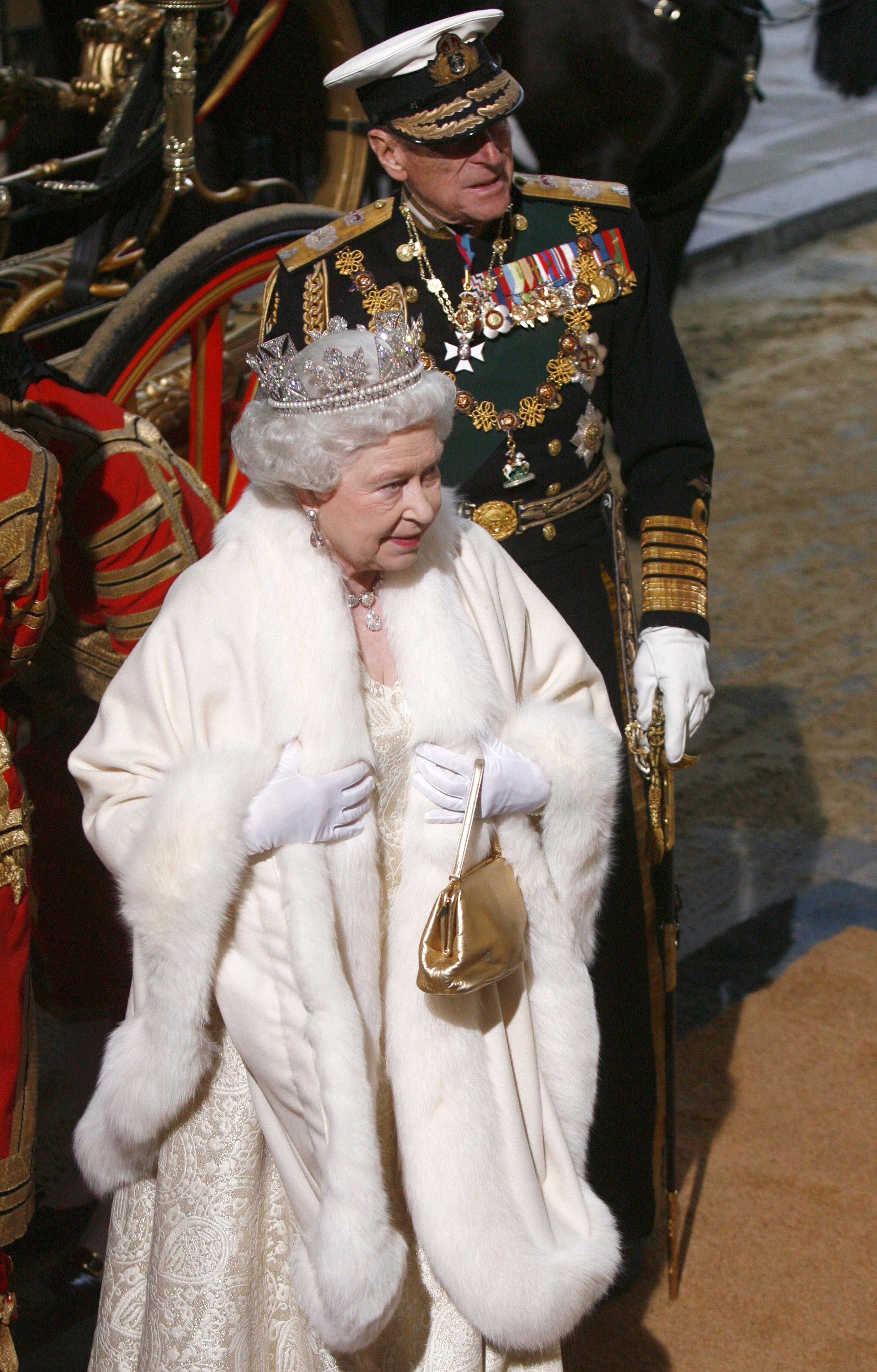 Britain's Queen Elizabeth II (L) and Prince Philip, the Duke of Edinburgh arrive in a horse-drawn carriage at the Houses of Parliament in central London for the State Opening of Parliament, in London, on November 18, 2009. British Prime Minister Gordon Brown unveiled a crackdown on the banking industry Wednesday as part of a voter-friendly agenda designed to boost its chances at elections barely six months away. In a traditional Queen's Speech detailing its final legislative plans before ballots due by June, the government also put boosting growth and jobs as its top priority as Britain emerges from the global slowdown. (Photo credit JOHNNY GREEN/AFP via Getty Images)