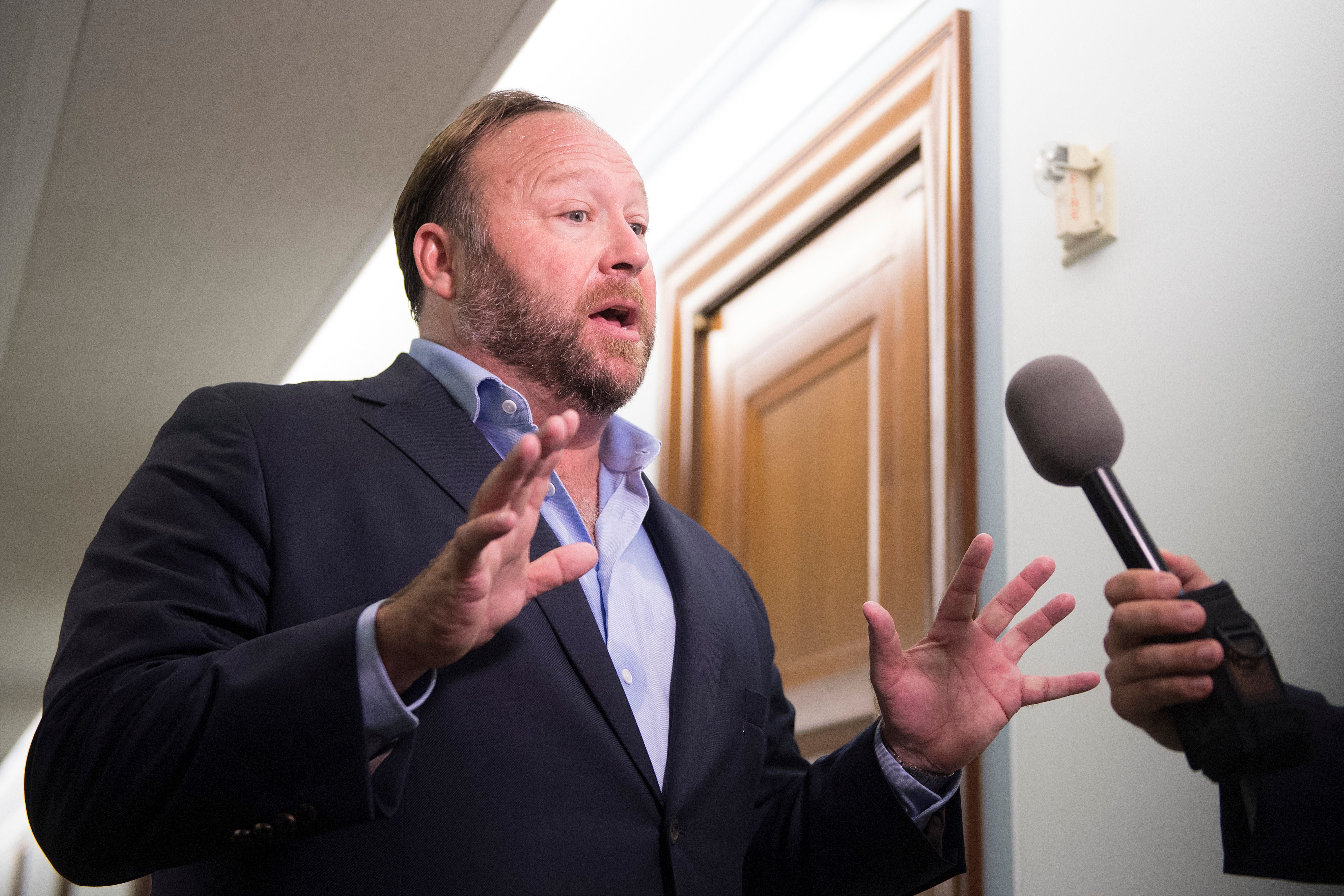 Alex Jones speaks with reporters outside as Twitter CEO Jack Dorsey and Facebook COO Sheryl Sandberg testify before the Senate Intelligence Committee. (JIM WATSON/AFP via Getty Images)