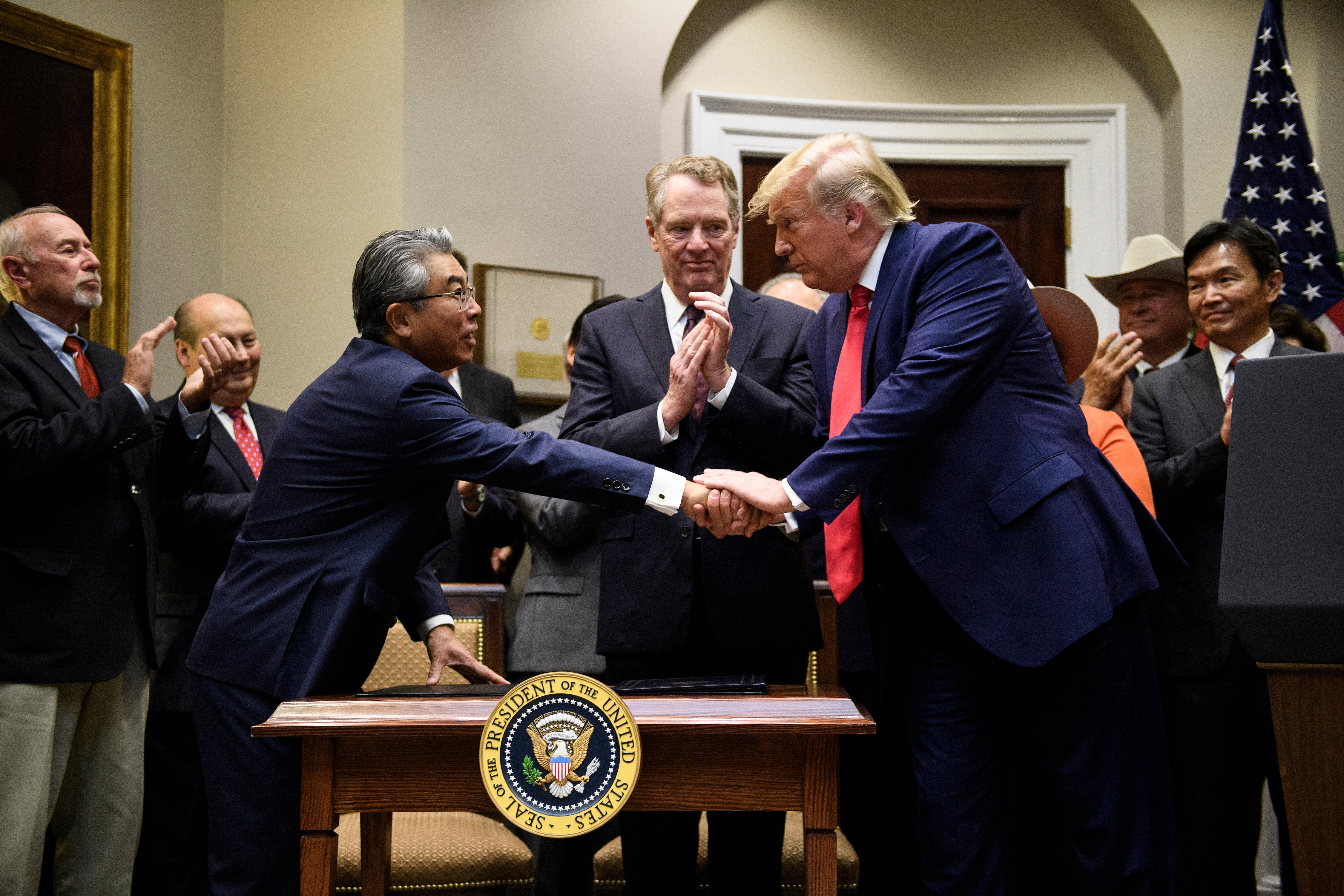 US Trade Representative Robert Lighthizer (C) watches as US President Donald Trump shakes the hand of Japan's US Ambassador Shinsuke Sugiyama (L) during a signing ceremony of a US-Japanese trade agreement in the Roosevelt Room of the White House October 7, 2019, in Washington, DC. (Photo by BRENDAN SMIALOWSKI/AFP via Getty Images)