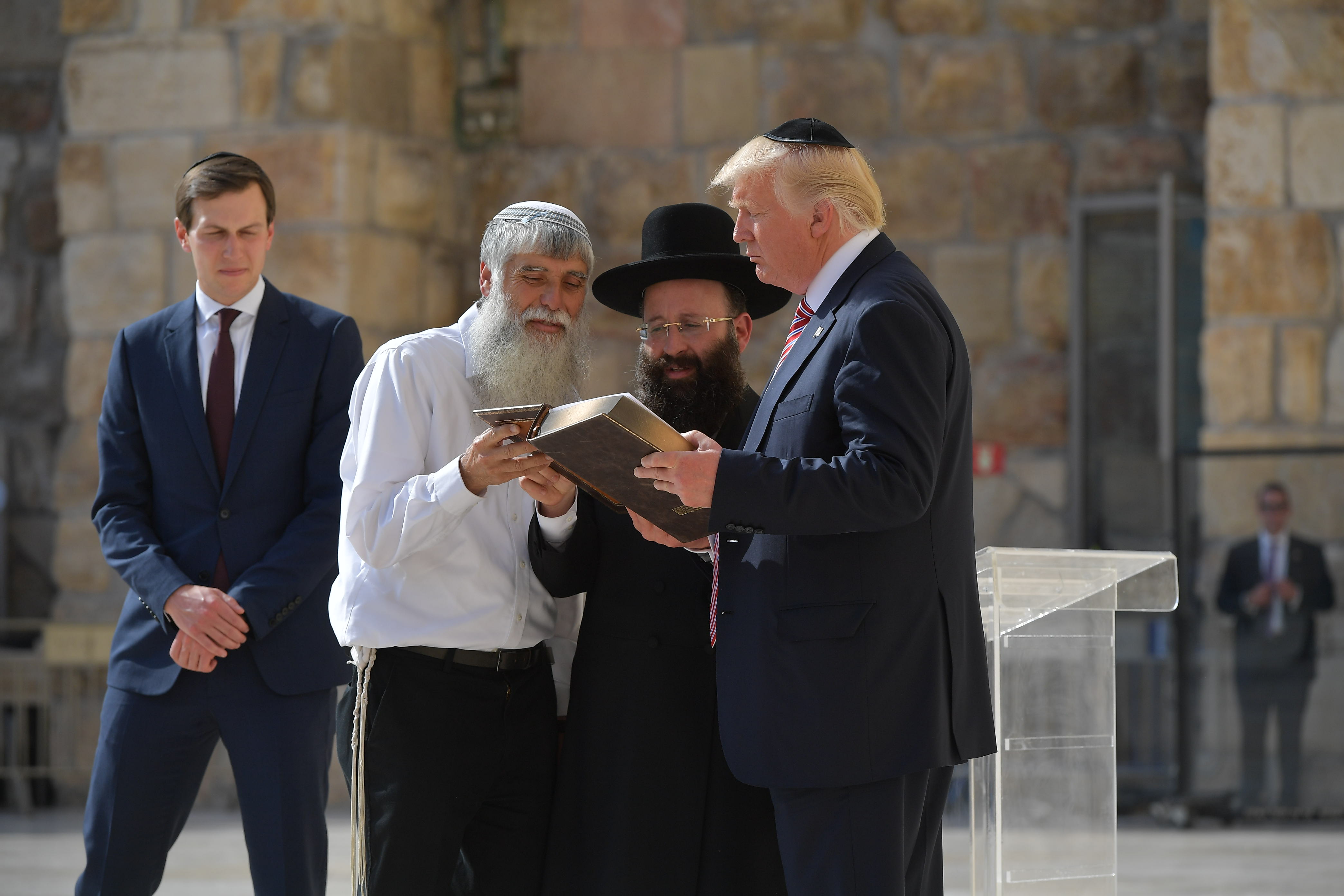 US President Donald Trump listens to Rabbi Shmuel Rabinovitch (C) during a visit to the Western Wall, the holiest site where Jews can pray, in Jerusalems Old City on May 22, 2017. On the left, Trump's son-in-law and senior advisor Jared Kushner. (Photo: MANDEL NGAN/AFP via Getty Images)