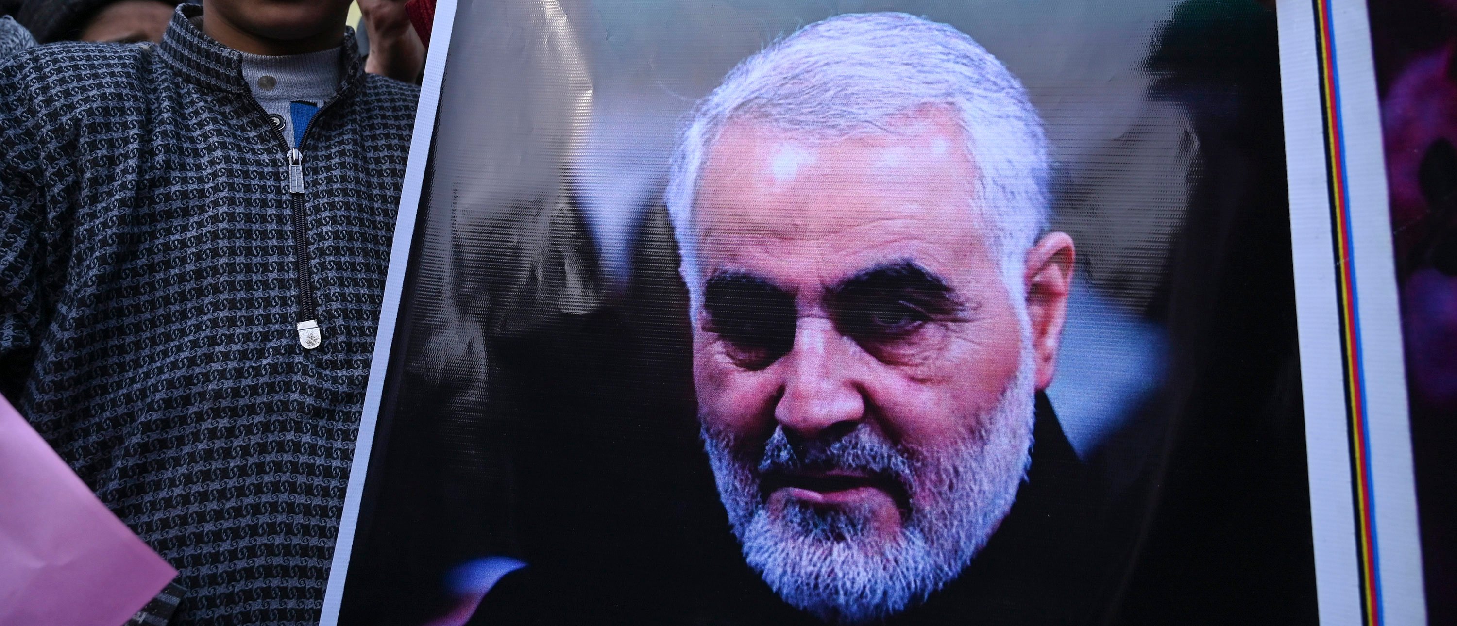 A protester holds a poster with the image of top Iranian commander Qasem Soleimani, who was killed in a US airstrike in Iraq, in the Kashmiri town of Magam on January 3, 2020. - Hundreds of people in Indian Kashmir staged "anti-American" demonstrations in the troubled territory on January 3 within hours of US forces killing a top Iranian commander. (Photo by TAUSEEF MUSTAFA/AFP via Getty Images)