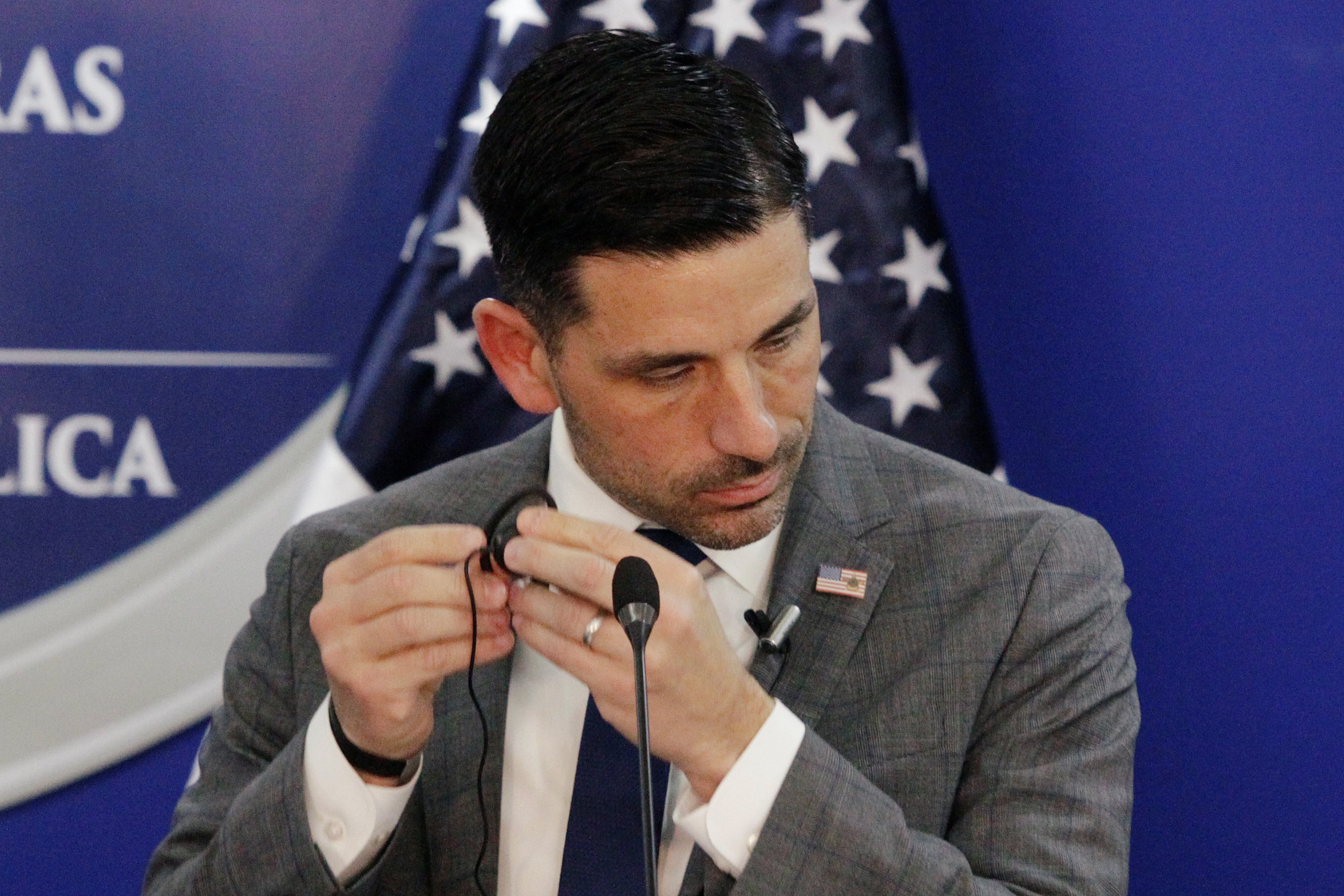 U.S. Department of Homeland Security (DHS) acting Secretary Chad Wolf adjusts an earpiece during a joint message with Honduras' President Juan Orlando Hernandez (not pictured), in Tegucigalpa