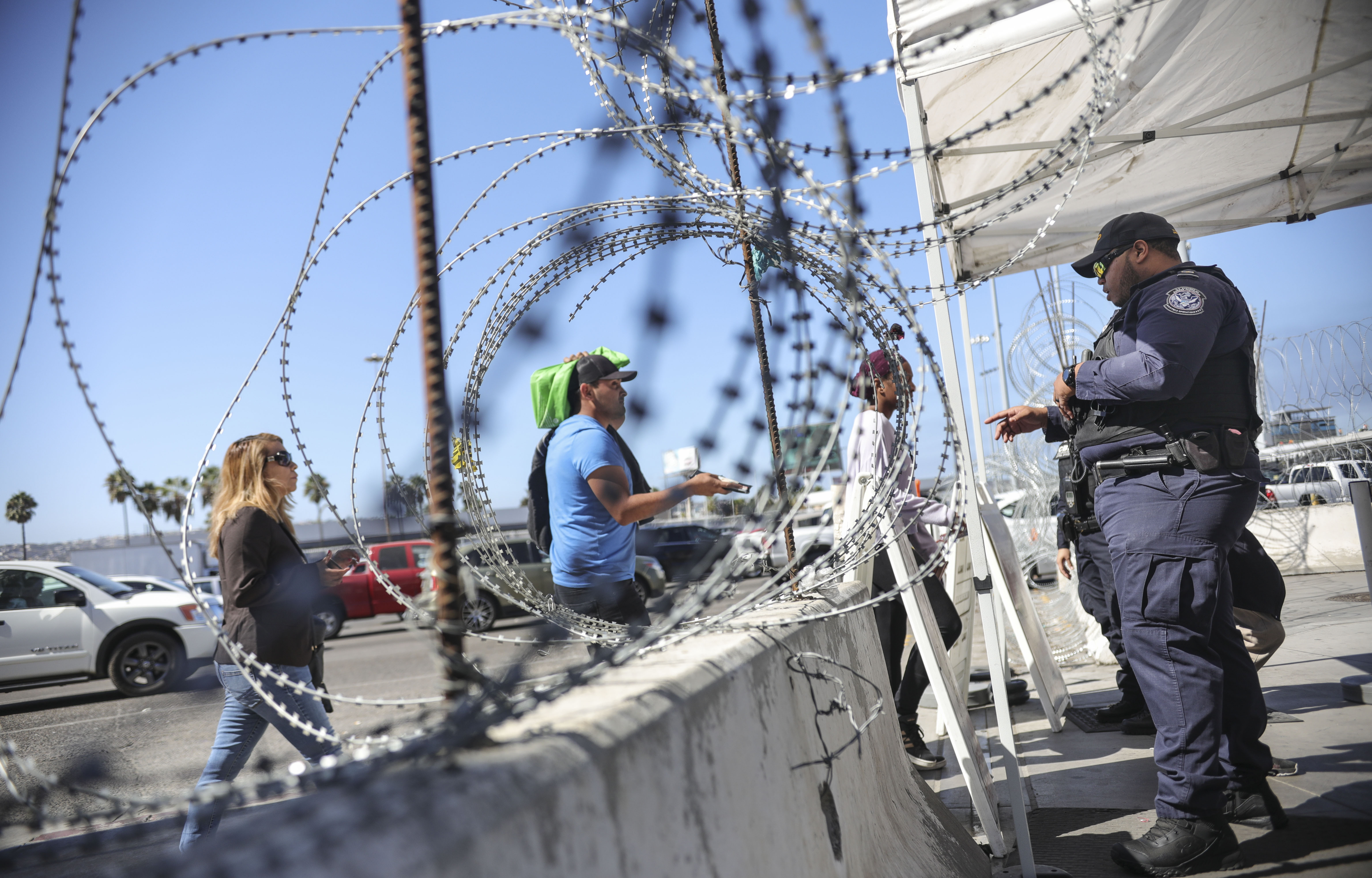 An Immigration and Customs Enforcement (ICE) agents check pedestrians' documentation at the San Ysidro Port of Entry on October 2, 2019 in San Ysidro, California. - Fentanyl, a powerful painkiller approved by the US Food and Drug Administration for a range of conditions, has been central to the American opioid crisis which began in the late 1990s. China was the first country to manufacture illegal fentanyl for the US market, but the problem surged when trafficking through Mexico began around 2005, according to Donovan. (Photo by SANDY HUFFAKER / AFP) (Photo by SANDY HUFFAKER/AFP via Getty Images)