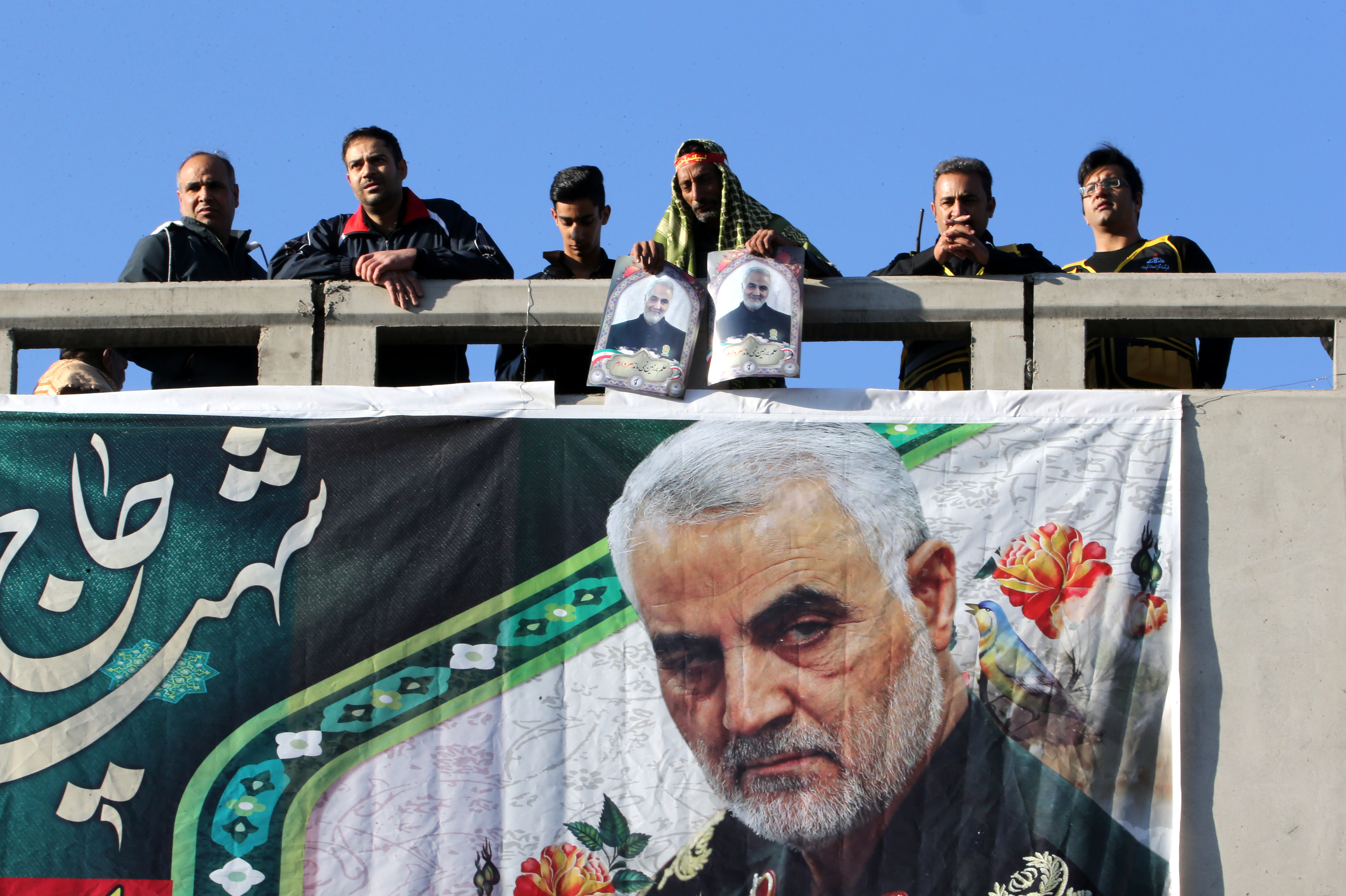 Iranian mourners stand on a bridge during the final stage of funeral processions for slain top general Qasem Soleimani, in his hometown Kerman on January 7, 2020. - Soleimani was killed outside Baghdad airport on January 3 in a drone strike ordered by US President Donald Trump, ratcheting up tensions with arch-enemy Iran which has vowed "severe revenge". The assassination of the 62-year-old heightened international concern about a new war in the volatile, oil-rich Middle East and rattled financial markets. (Photo by ATTA KENARE / AFP) (Photo by ATTA KENARE/AFP via Getty Images)