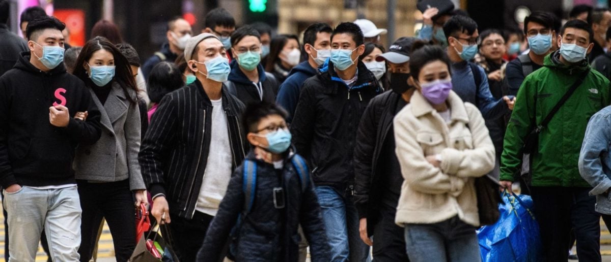 Pedestrians wearing face masks cross a road during a Lunar New Year of the Rat public holiday in Hong Kong on January 27, 2020, as a preventative measure following a coronavirus outbreak which began in the Chinese city of Wuhan. (Photo by ANTHONY WALLACE/AFP via Getty Images)