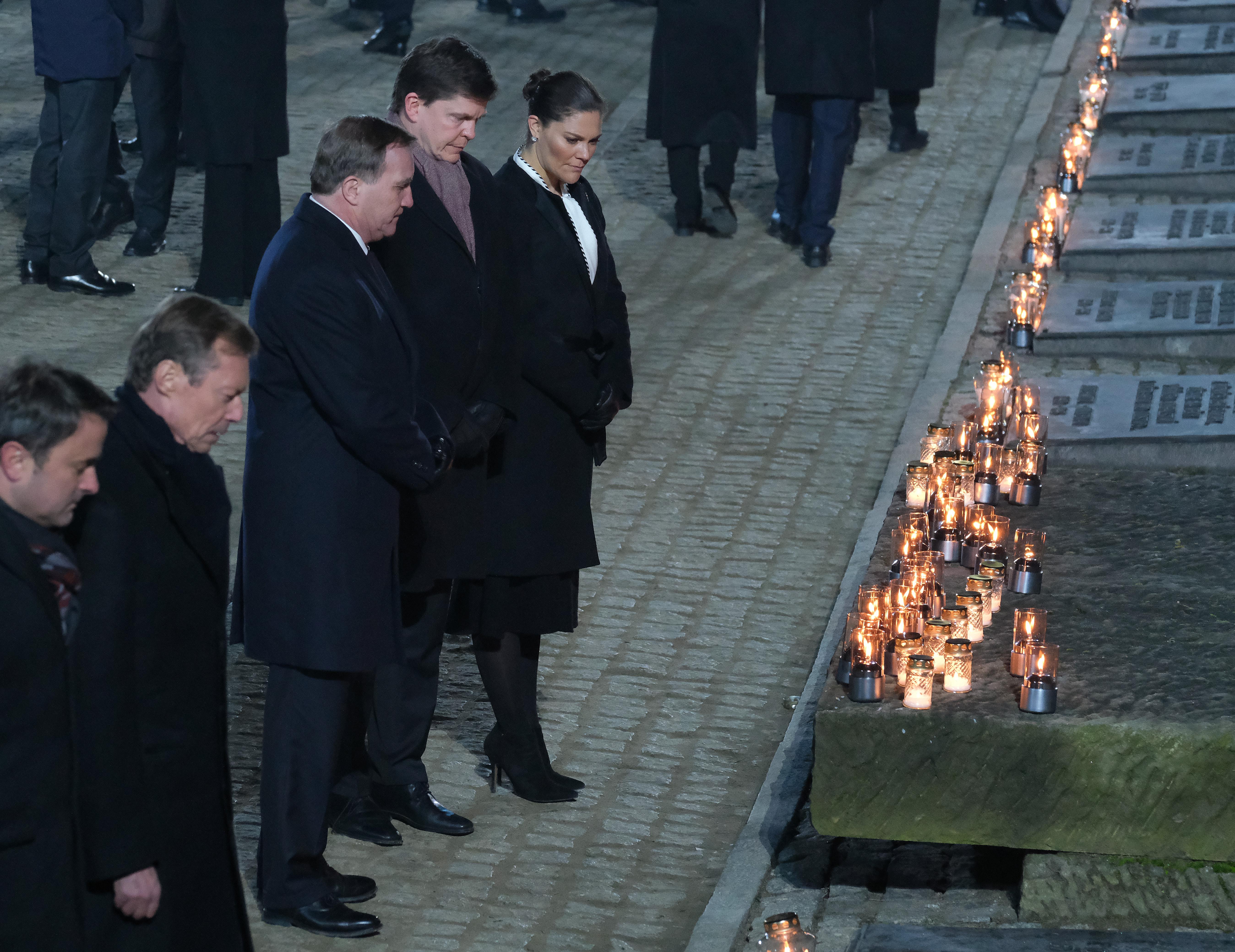 OSWIECIM, POLAND - JANUARY 27: Swedish Crown Princess Victoria, Swedish Prime Minister Stefan Löfven and her husband Prince Daniel look at candles at the Auschwitz Memorial during the official ceremony to mark the 75th anniversary of the liberation of the Auschwitz concentration camp at the Auschwitz-Birkenau site on January 27, 2020 near Oswiecim, Poland. International leaders as well as approximately 200 survivors and their families are gathering today at Auschwitz today to attend the commemoration. The Nazis killed an estimated one million people at the camp during the World War II occupation of Poland by Nazi Germany. The Soviet Army liberated the camp on January 27, 1945. (Photo by Sean Gallup/Getty Images)