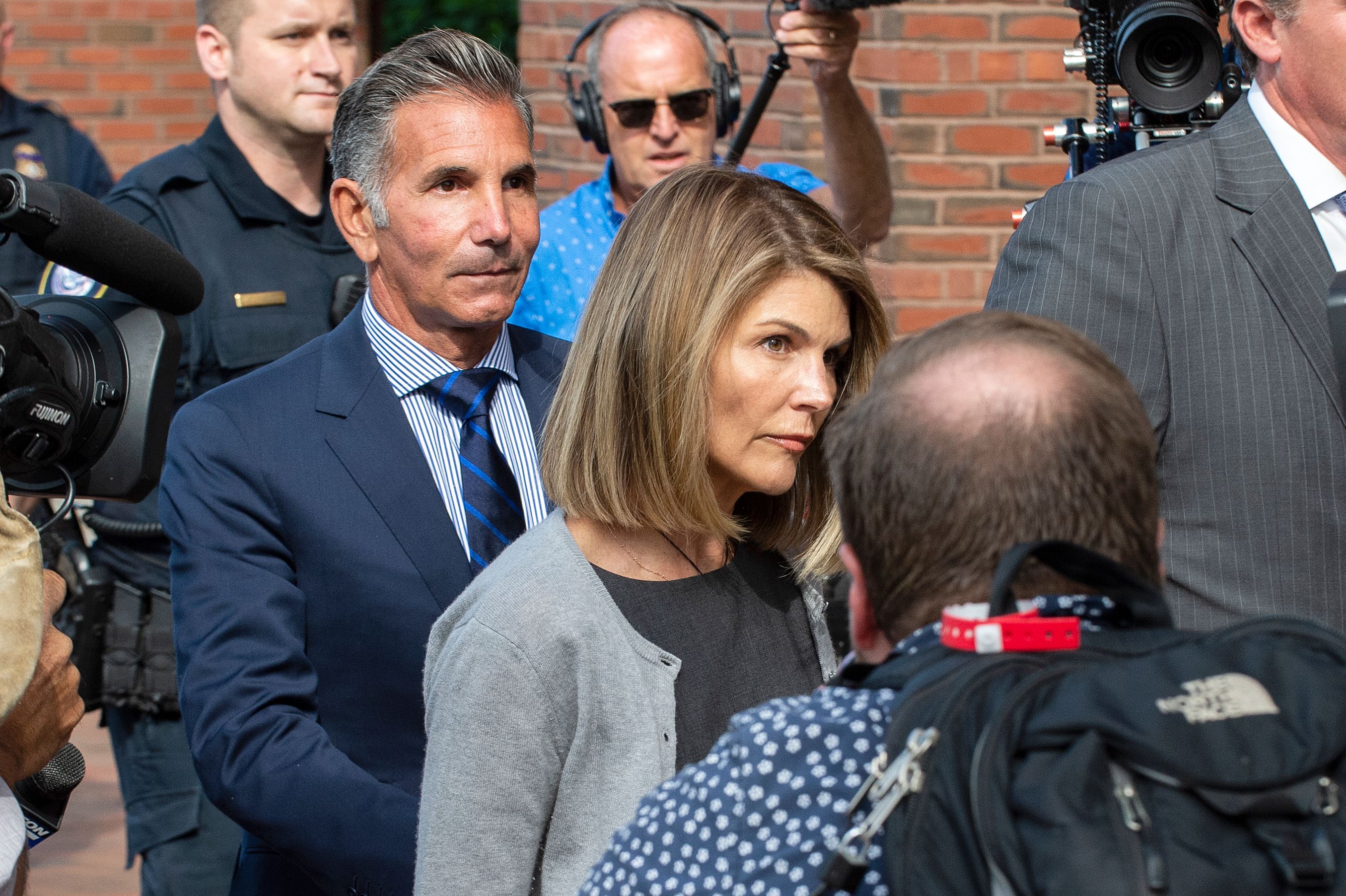 Actress Lori Loughlin and husband Mossimo Giannulli exit the Boston Federal Court house after a pre-trial hearing with Magistrate Judge Kelley at the John Joseph Moakley US Courthouse in Boston on August 27, 2019. - Loughlin and Giannulli are charged with conspiracy to commit mail and wire fraud and conspiracy to commit money laundering in the college admissions scandal. (Photo credit JOSEPH PREZIOSO/AFP via Getty Images)